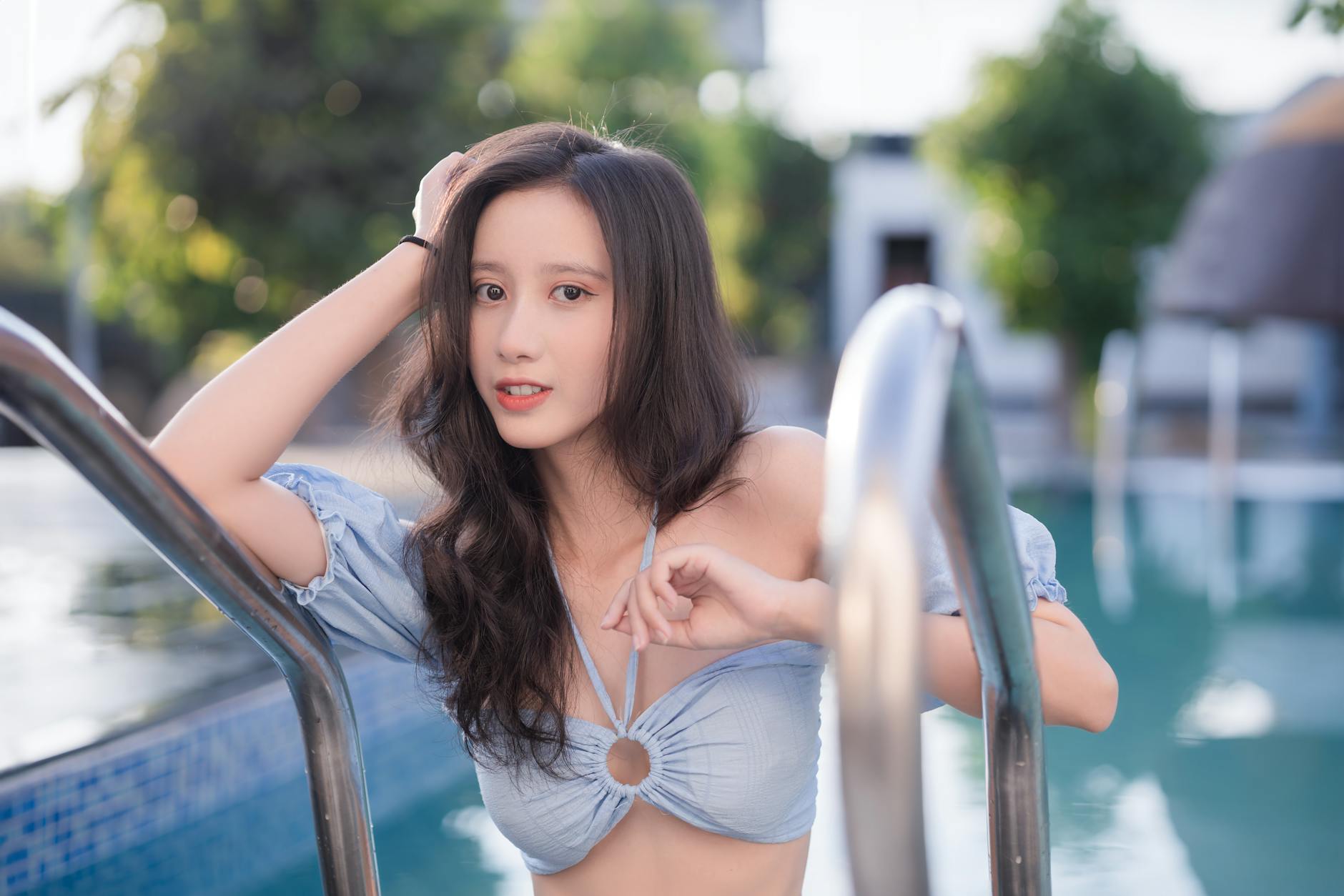 A young woman enjoys a sunny day at the pool, showcasing summer vibes.