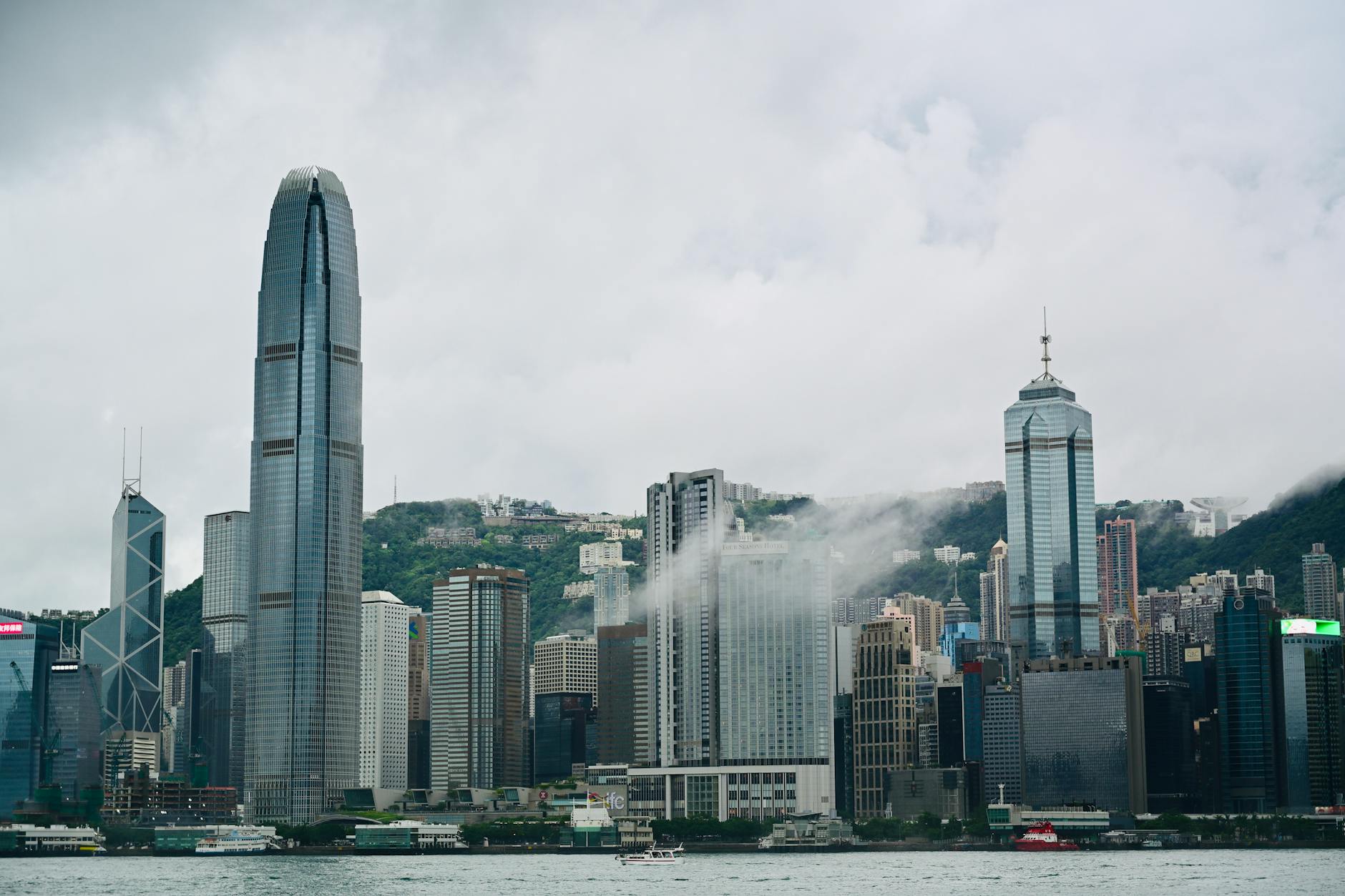 Stunning view of Hong Kong skyline with iconic skyscrapers under cloudy skies.