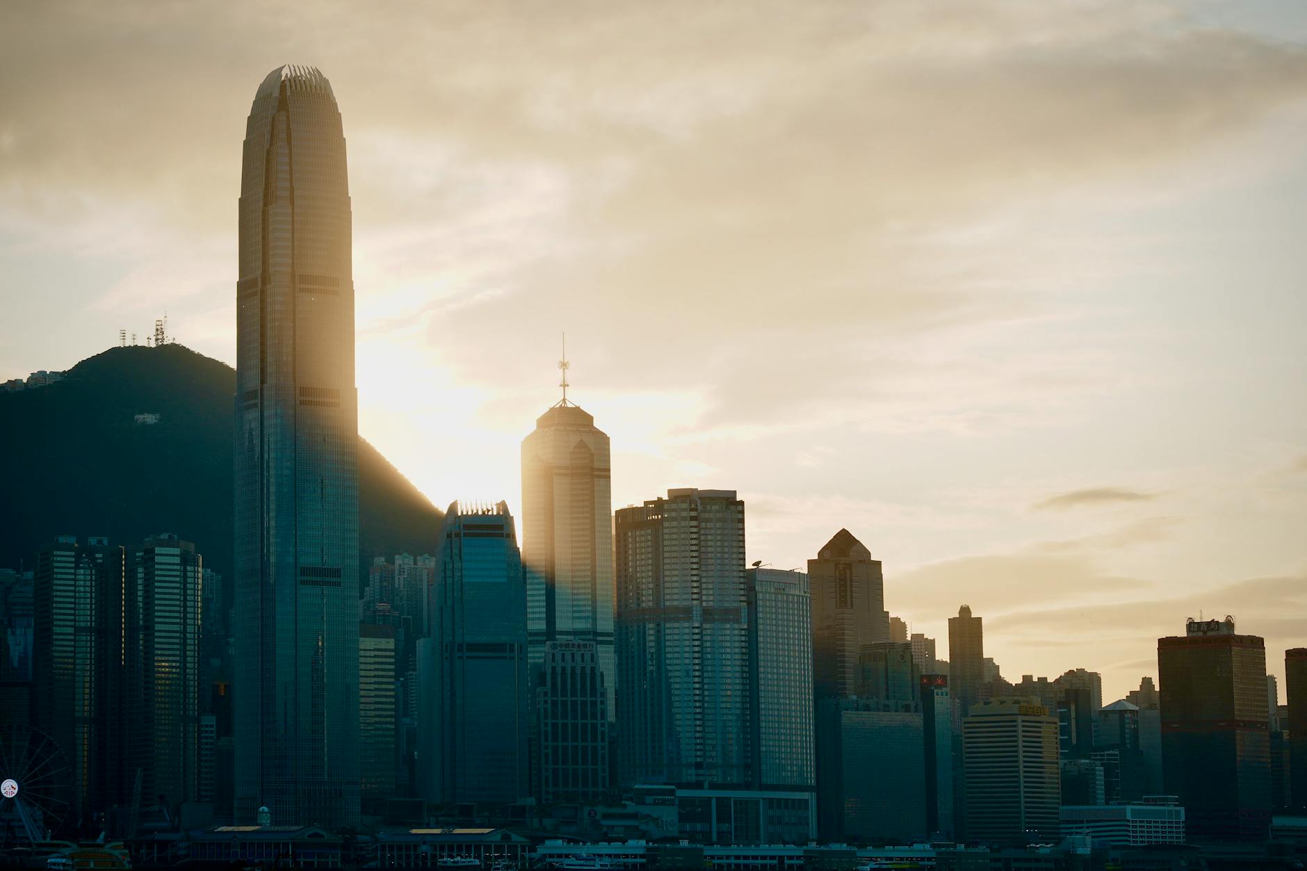 Dramatic sunset over Hong Kong's skyline featuring the iconic skyscrapers and cityscape.