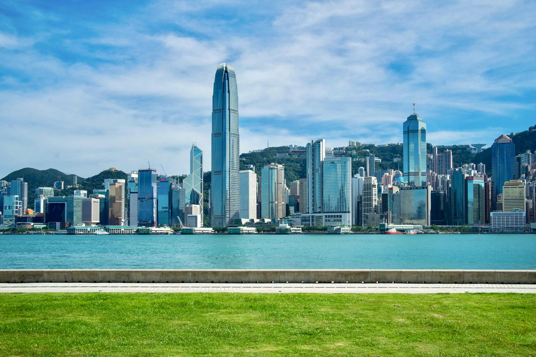 Breathtaking view of Hong Kong's iconic skyline with blue sky and waterfront.