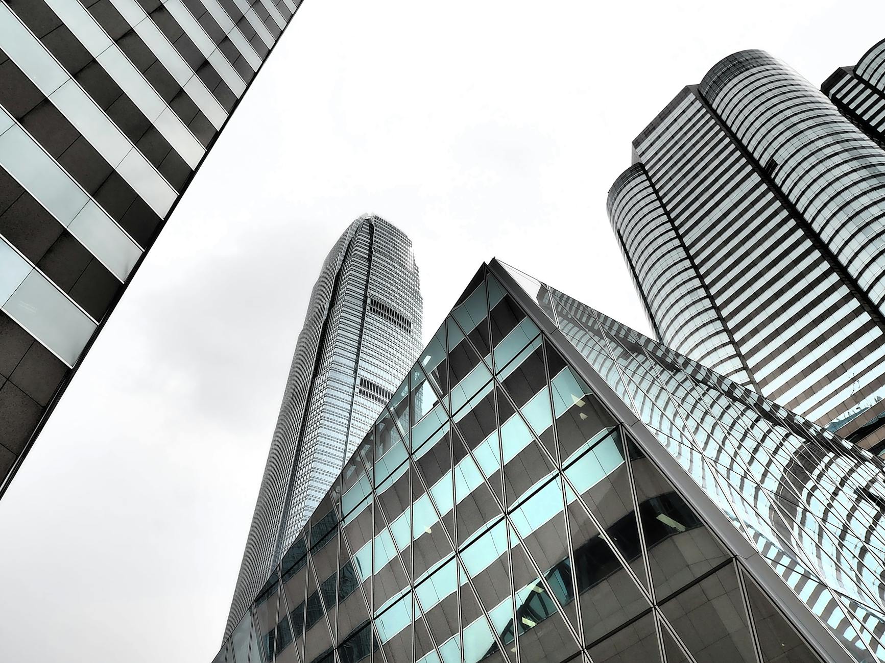 Striking modern architecture of Hong Kong's iconic skyscrapers under cloudy skies.