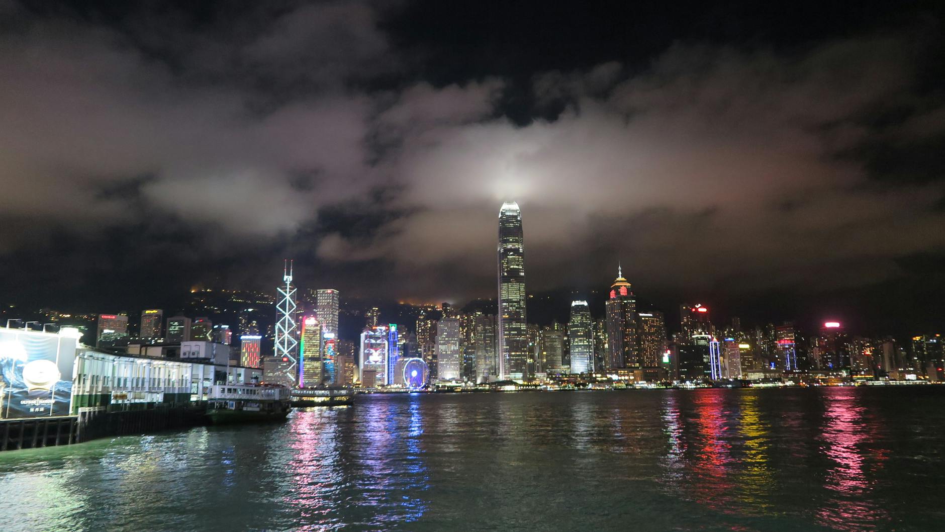 Breathtaking view of Hong Kong's skyline reflecting on the waterfront at night.