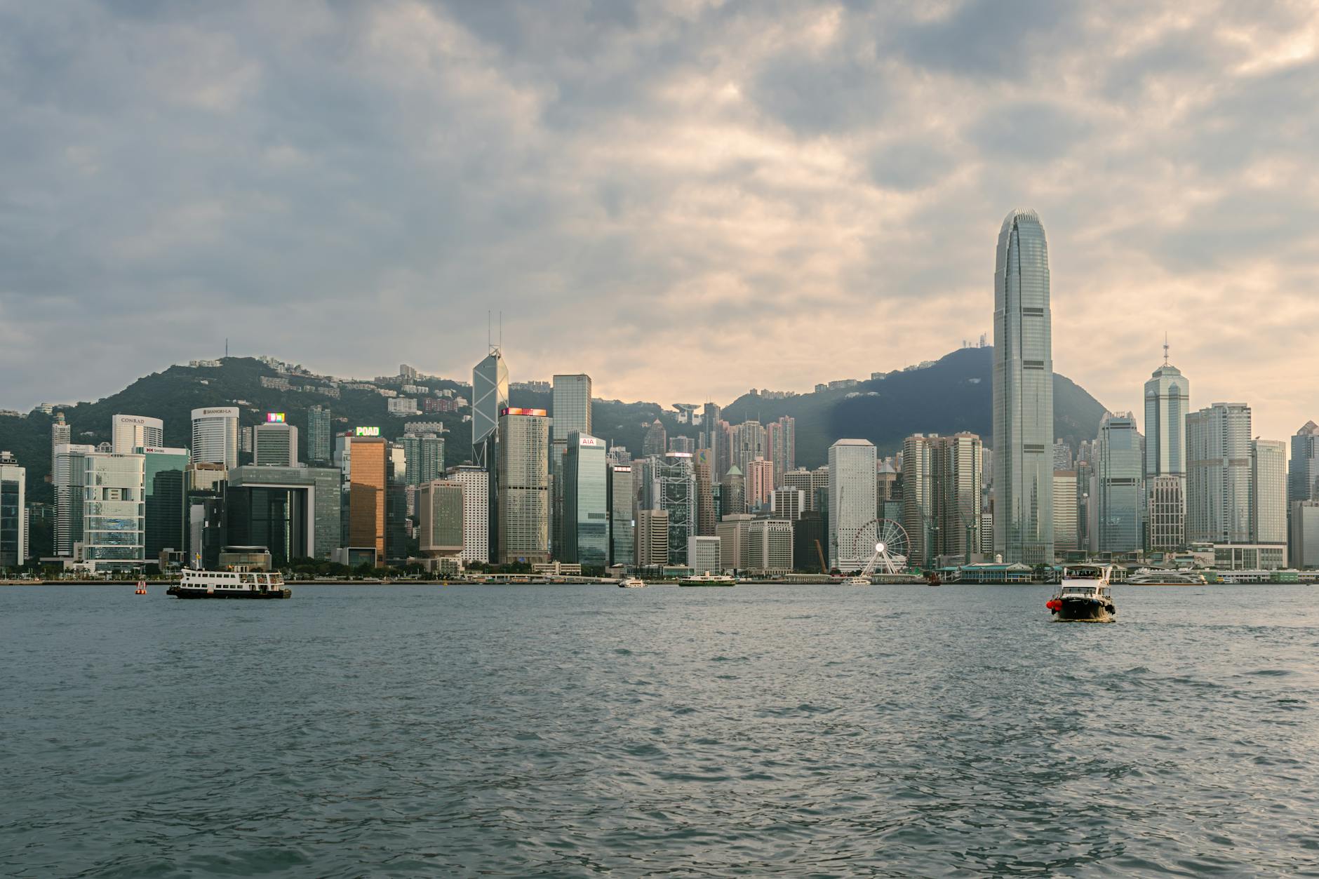 Stunning view of Hong Kong's skyline across Victoria Harbour with boats and skyscrapers.