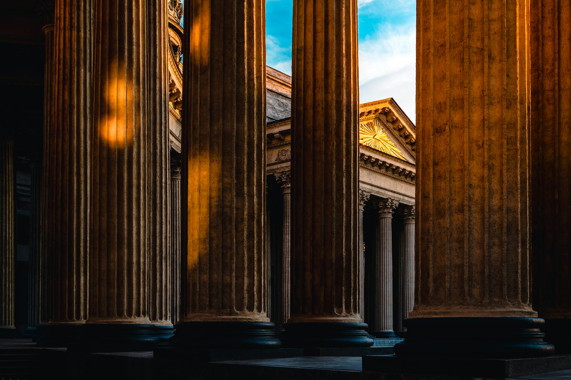 Golden light illuminating neoclassical columns, showcasing timeless architecture.