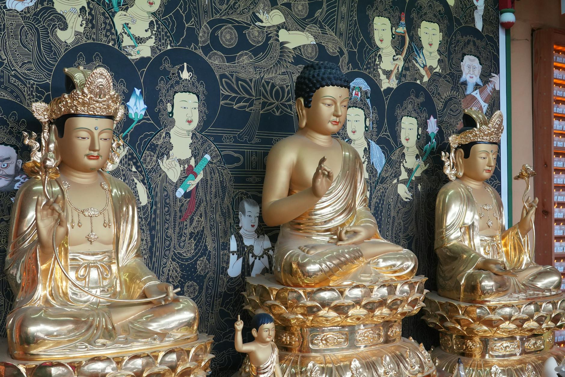 Ornate golden Buddha statues on display at a temple in Busan, South Korea.