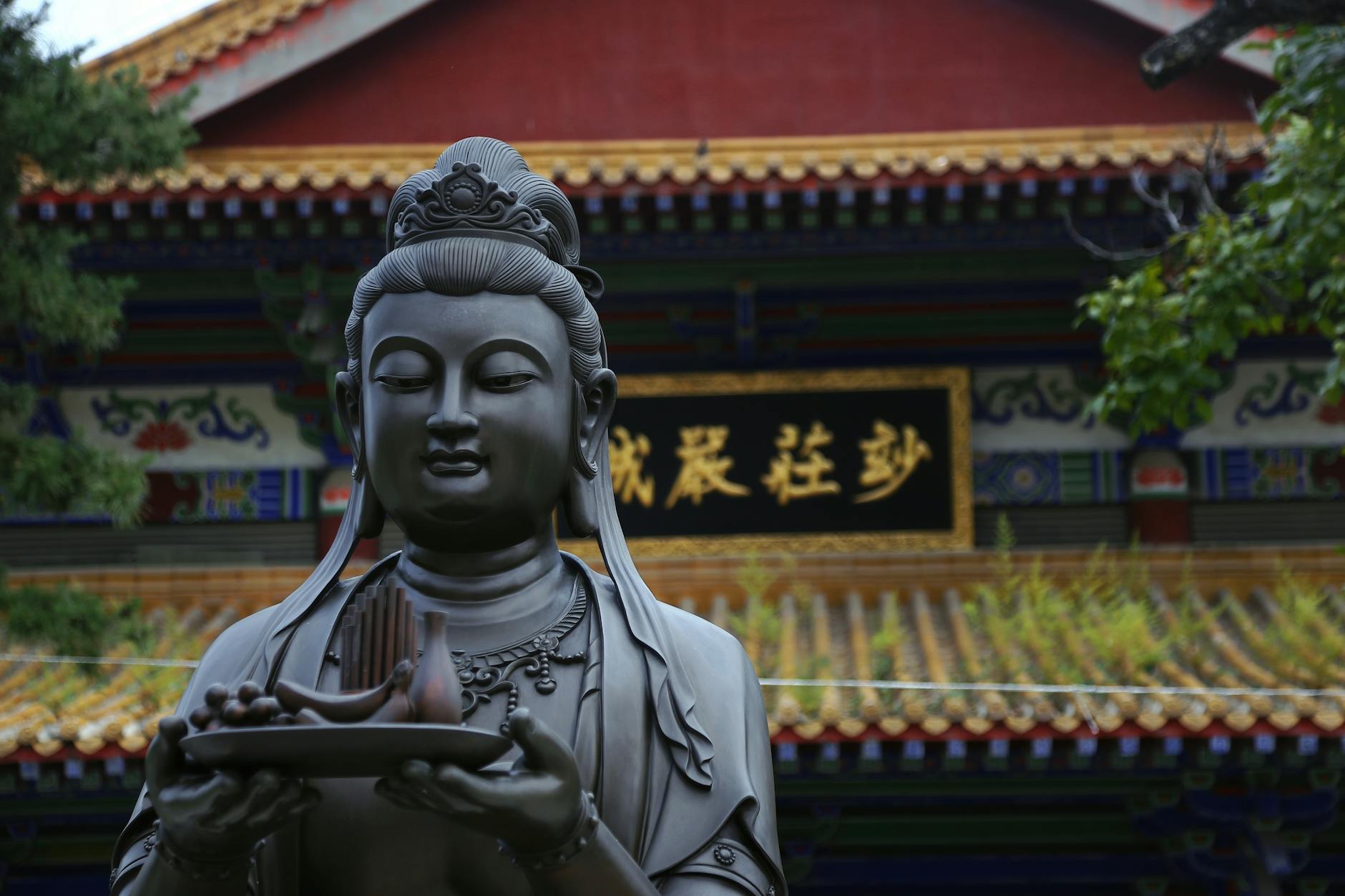 A detailed Buddha statue at an ornate Buddhist temple, symbolizing peace and spirituality.