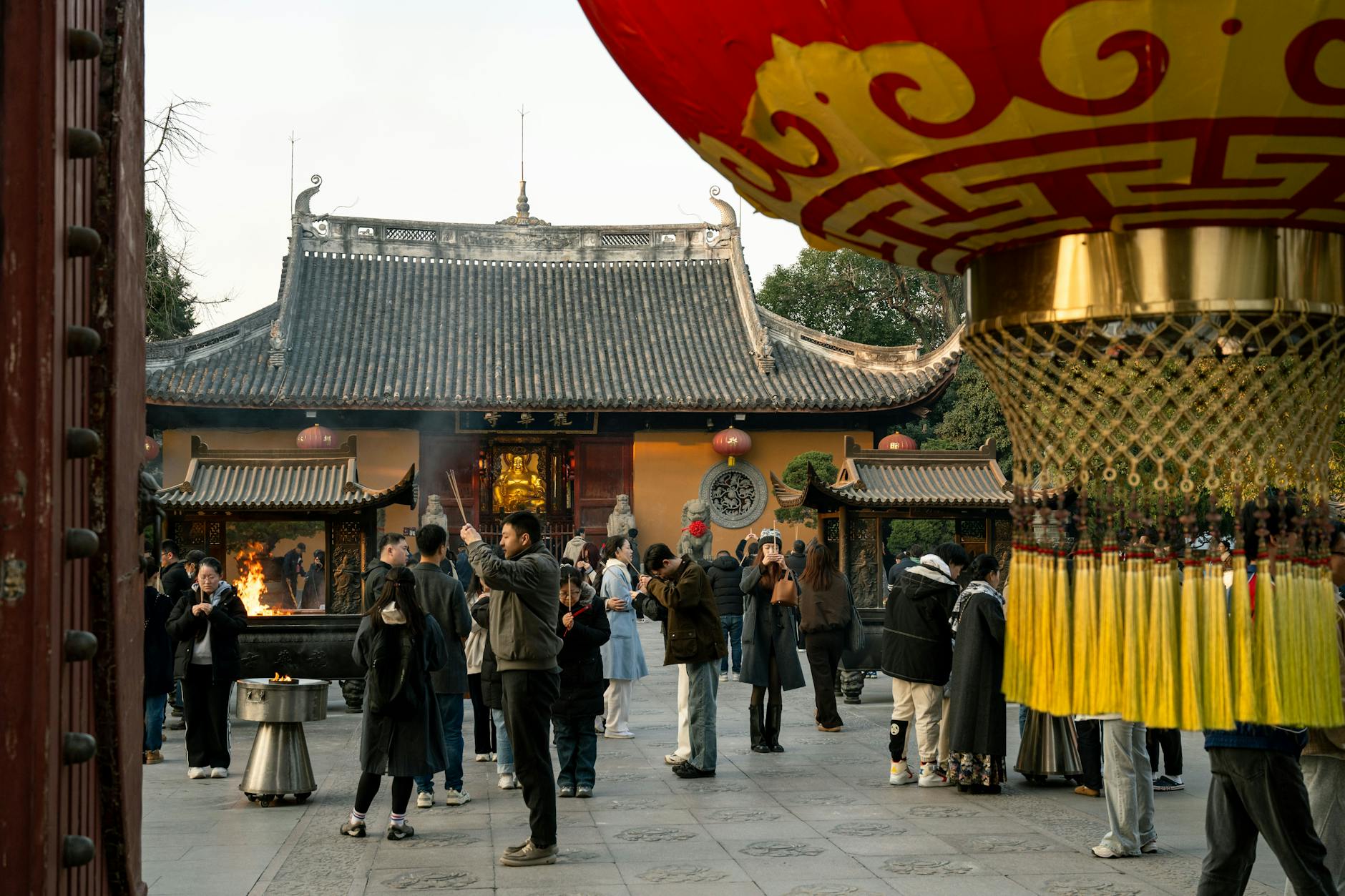 Group of people in a courtyard at Jingan Temple, Shanghai, enjoying the cultural ambiance.