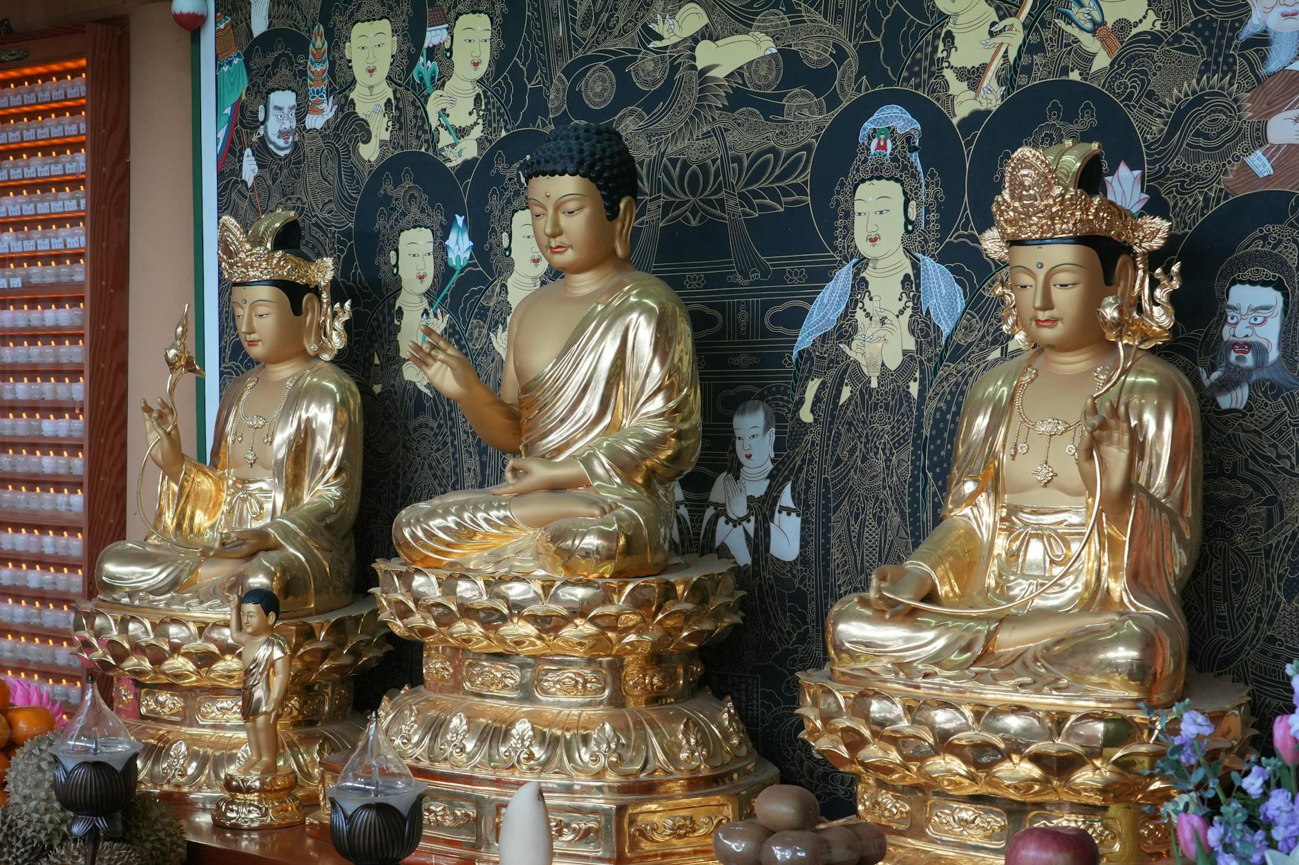 Elegant golden Buddha statues in a Busan temple showcasing intricate details and religious art.