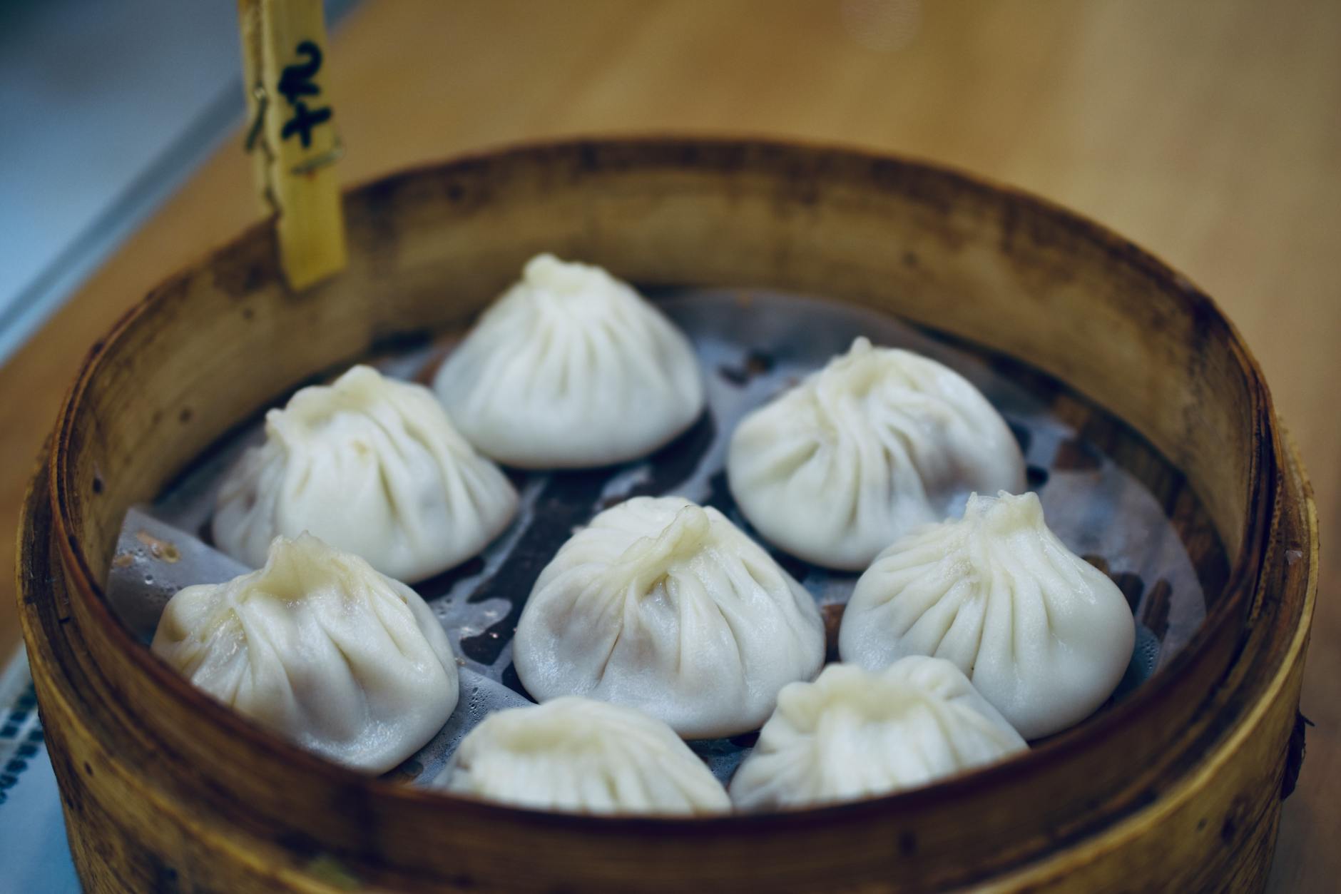 Close-up of Shanghai's famous xiao long bao dumplings in a bamboo steamer.