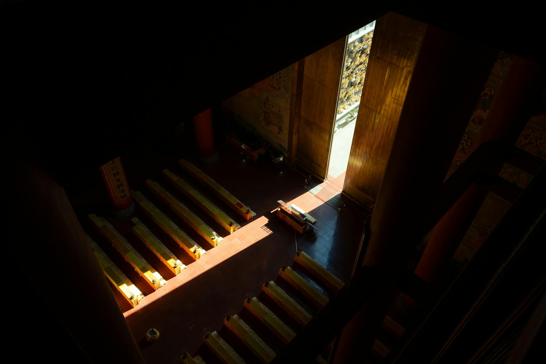 A serene view of a temple interior in Shanghai with sunlight creating dramatic patterns on the floor.