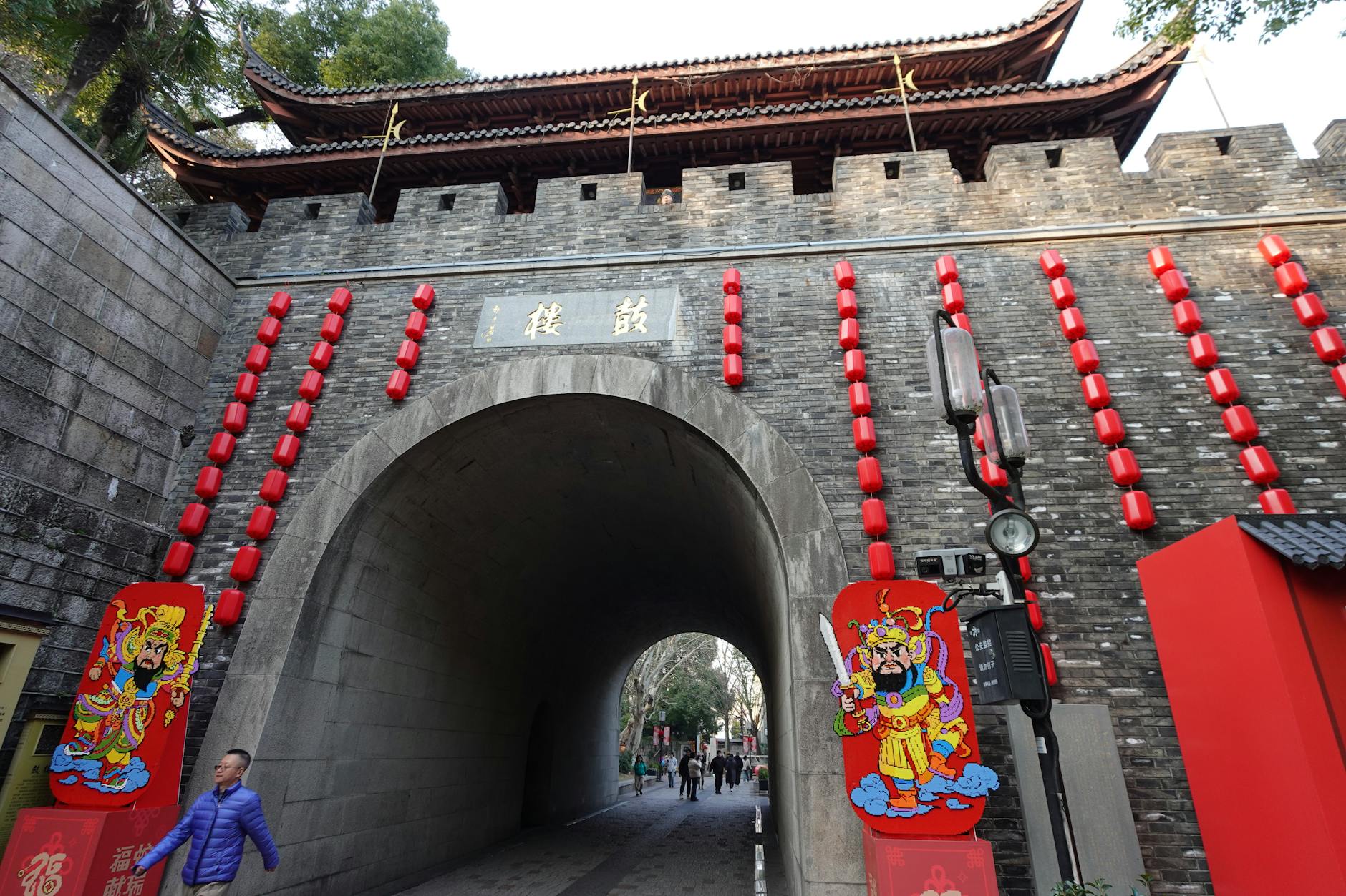 A historic city gate adorned with red lanterns in Hangzhou, featuring traditional architecture and festive decorations.