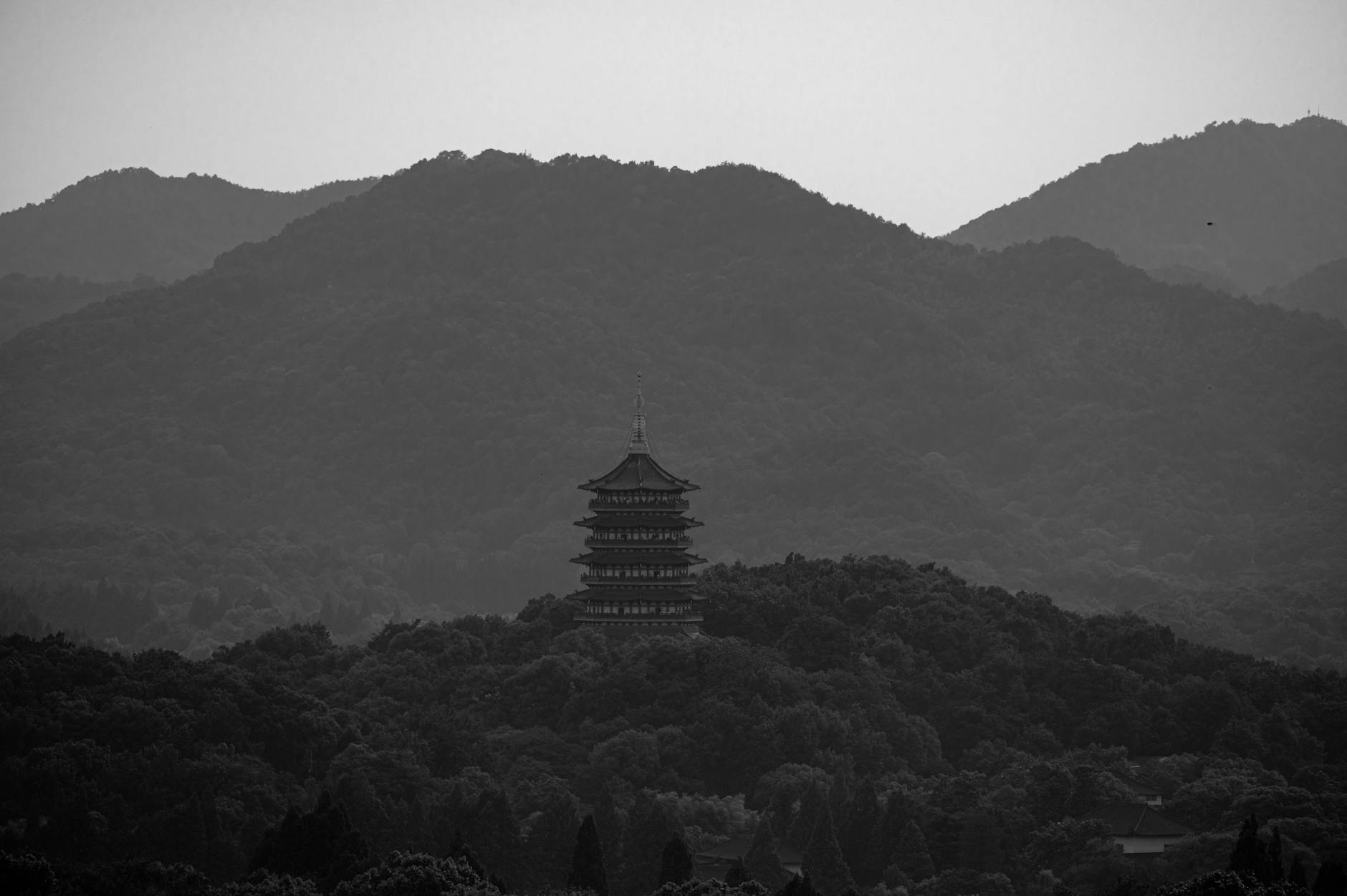 Scenic view of Leifeng Pagoda surrounded by forested hills in Hangzhou, China.