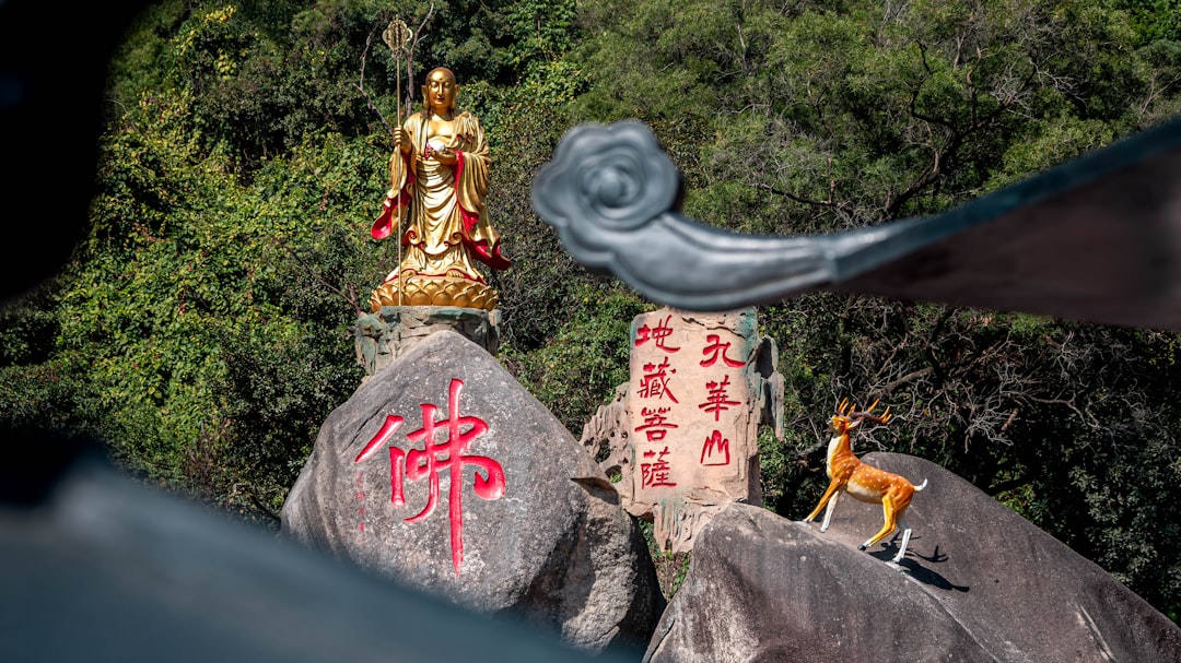 A statue of a person sitting on top of a rock
