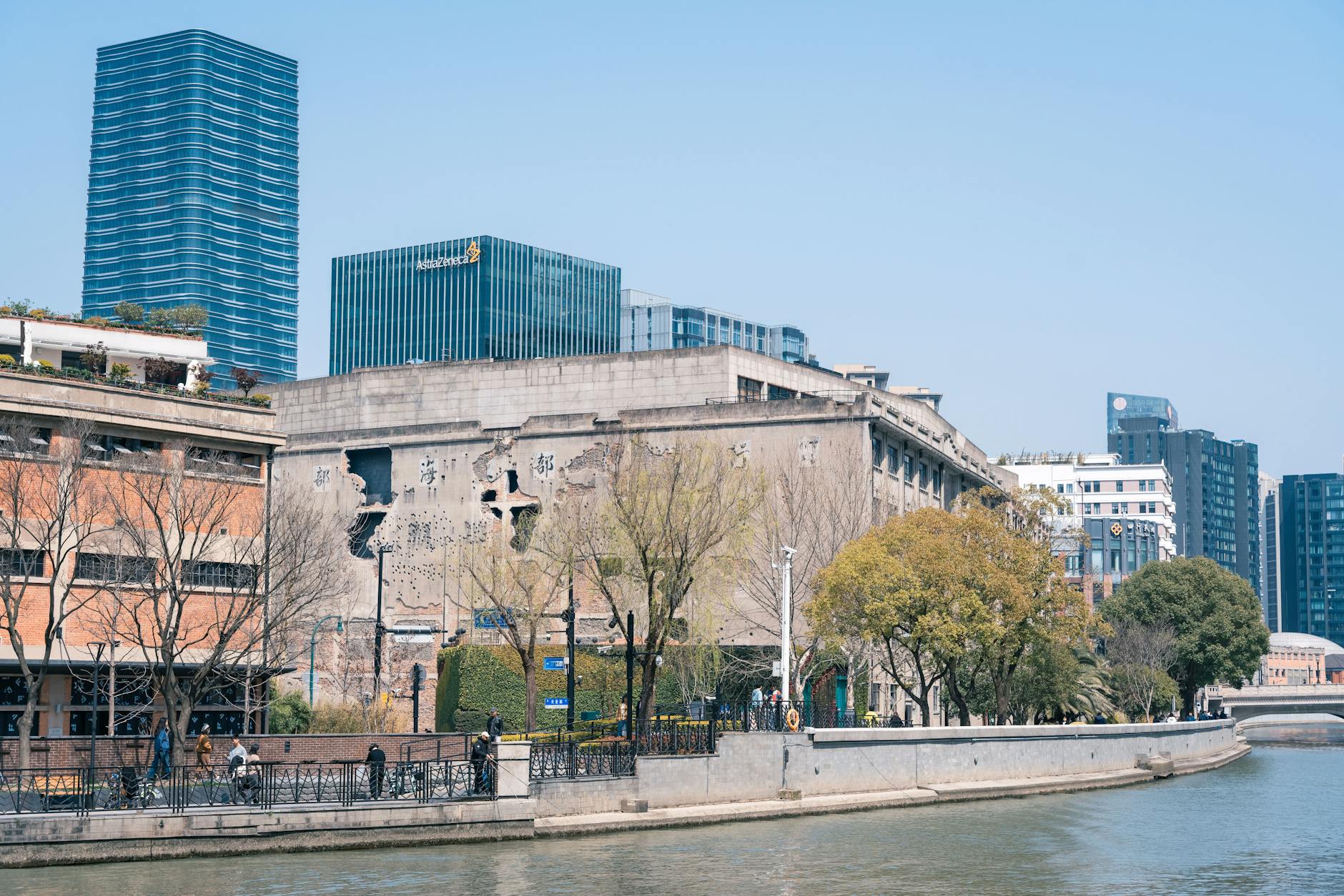 View of a city riverfront blending modern skyscrapers with historical architecture.