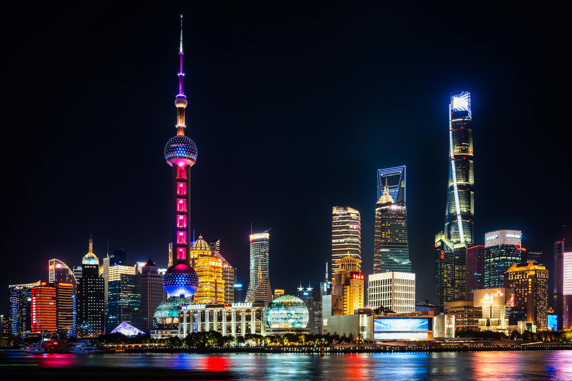 Vibrant night view of Shanghai's illuminated skyline featuring the iconic Oriental Pearl Tower.
