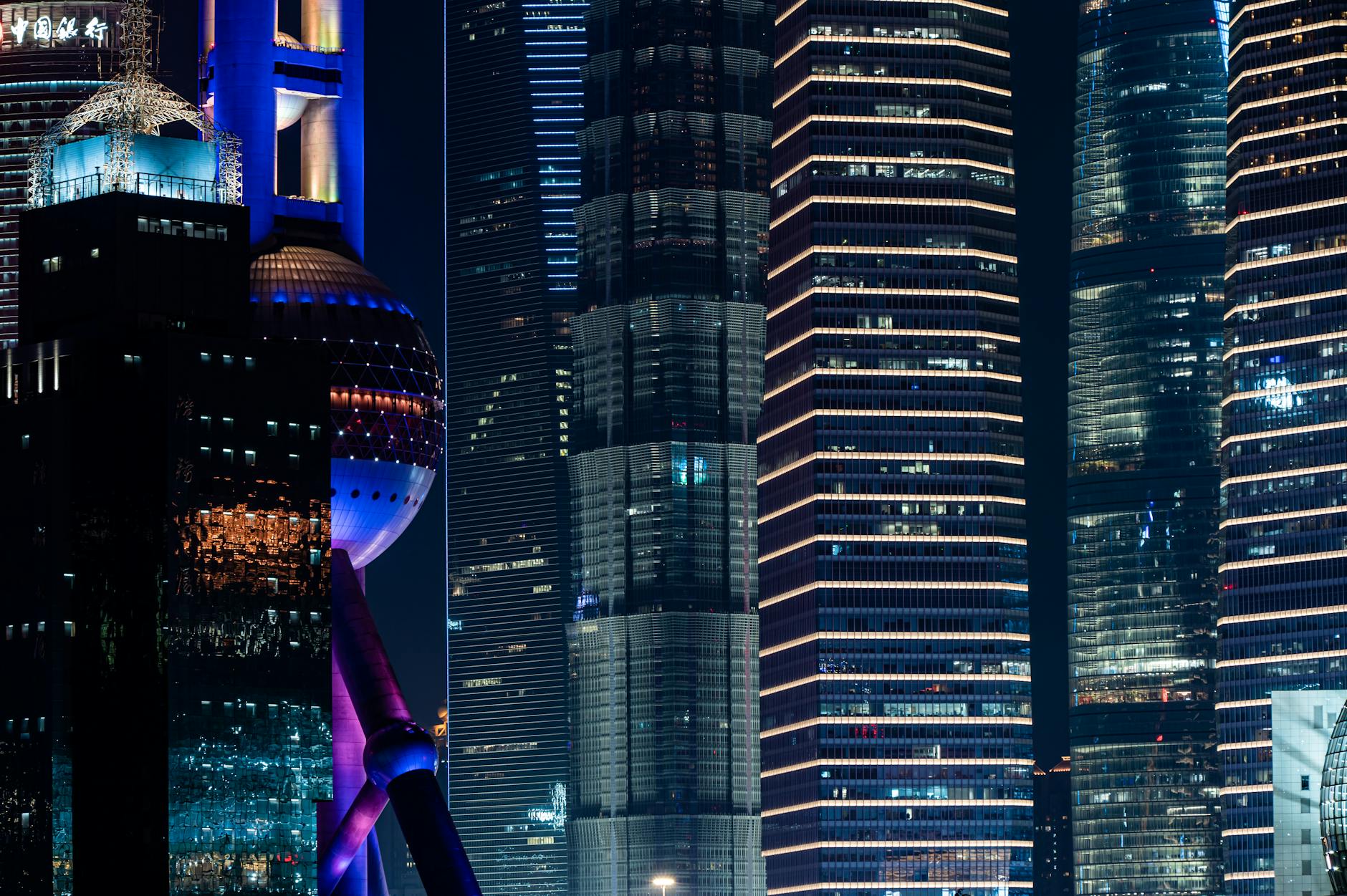 Night view of illuminated skyscrapers in Shanghai's cityscape showcasing modern architecture.