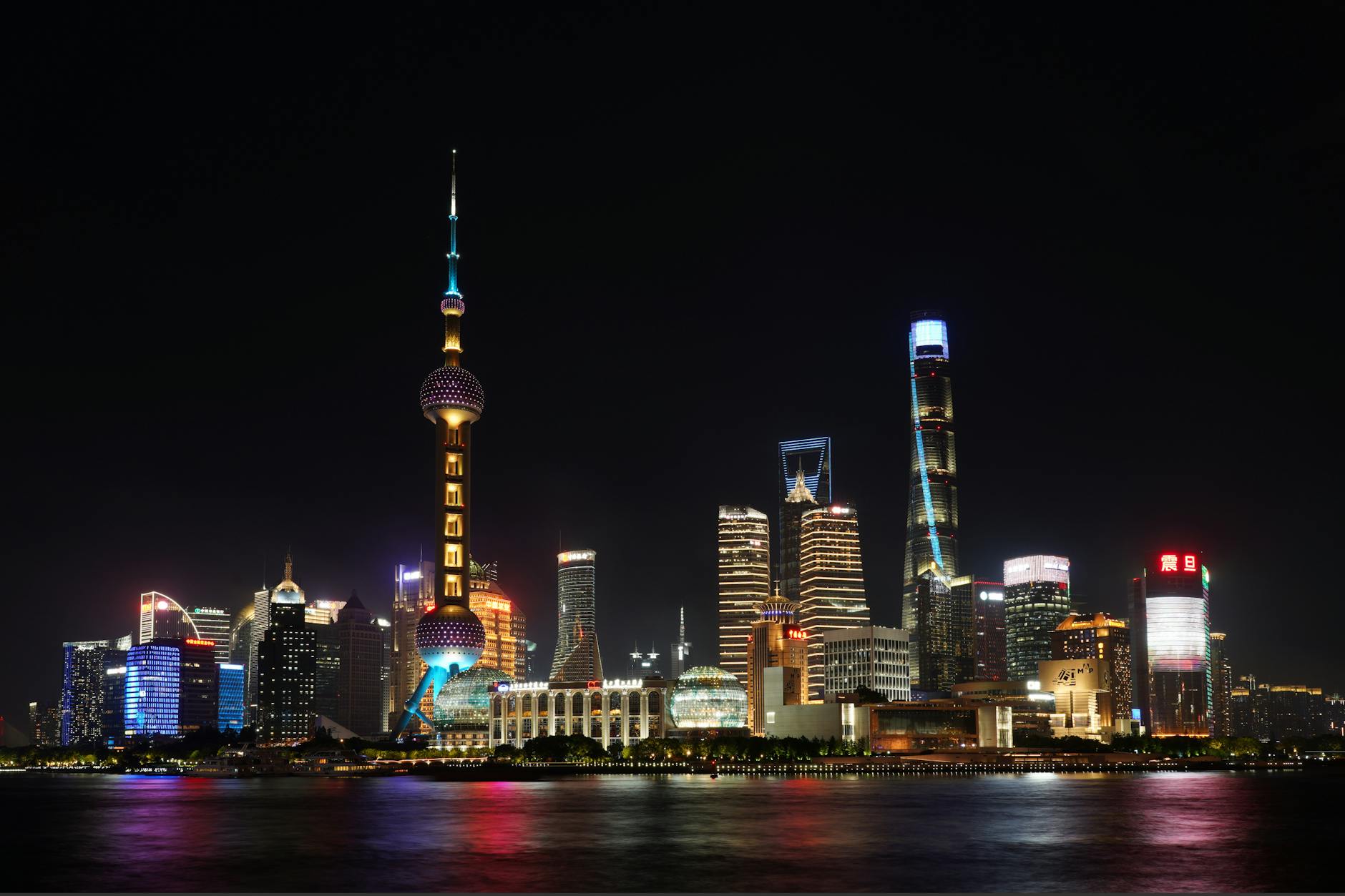 Stunning night view of Shanghai's skyline reflecting on the Huangpu River, featuring iconic skyscrapers.