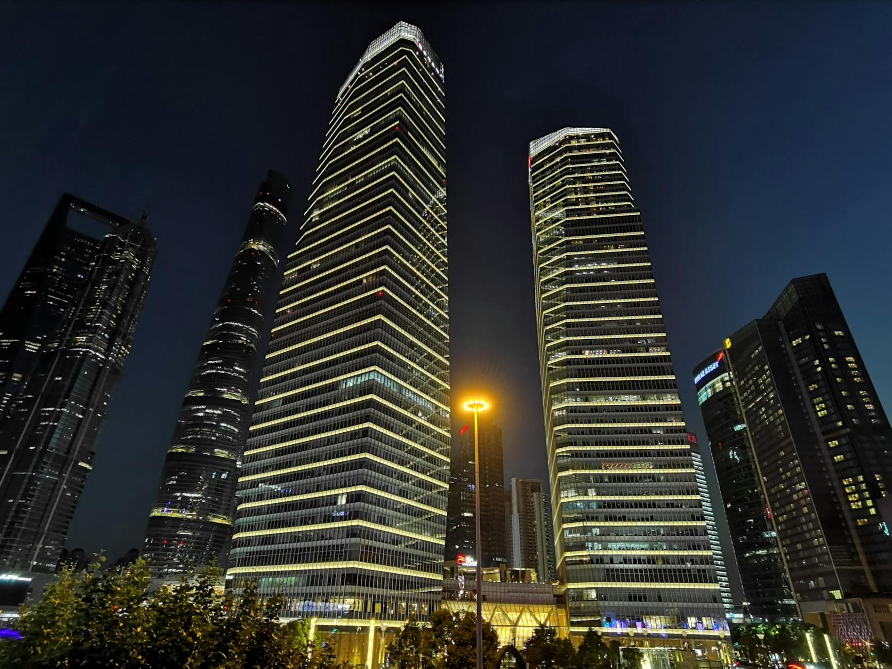 Night view of Shanghai's illuminated skyscrapers showcasing modern urban architecture.