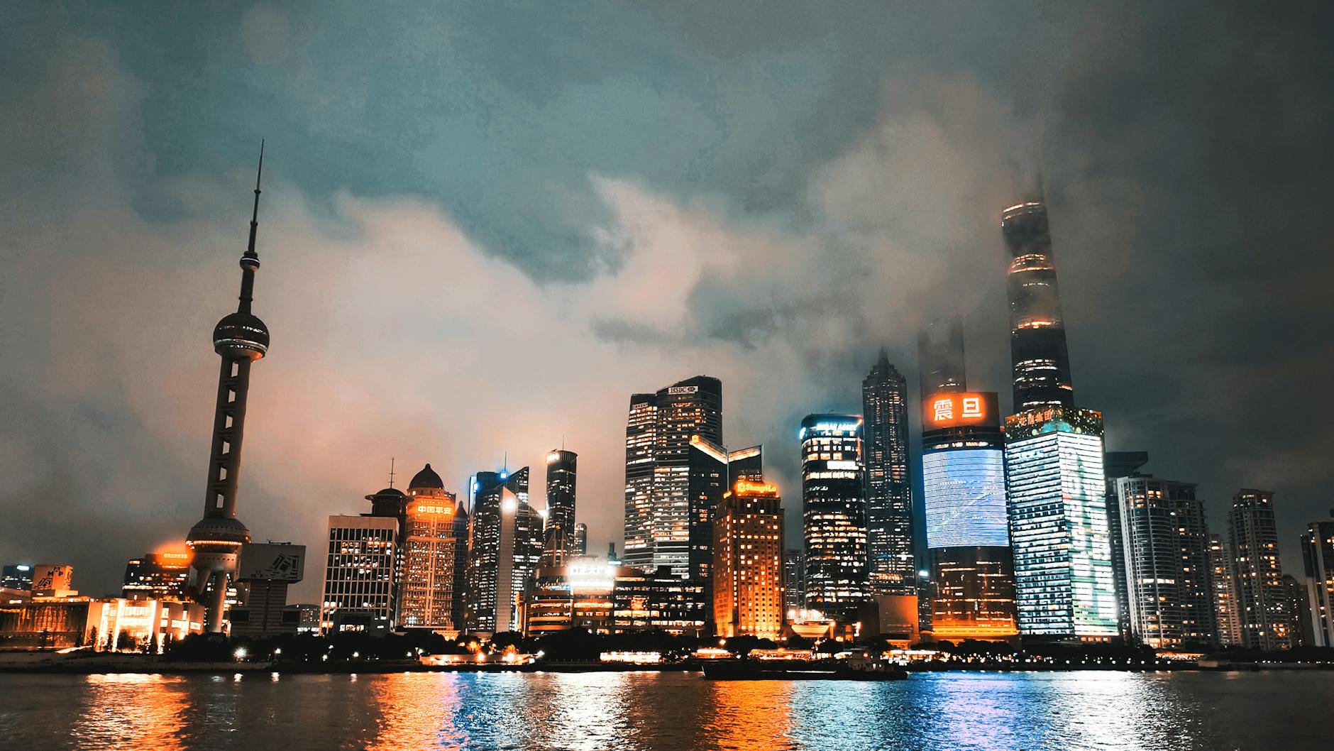 Captivating view of Shanghai's illuminated skyline reflecting on the Huangpu River at night.