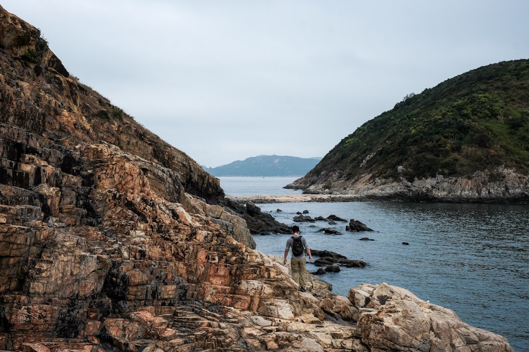 A hiker explores a rocky coastline.