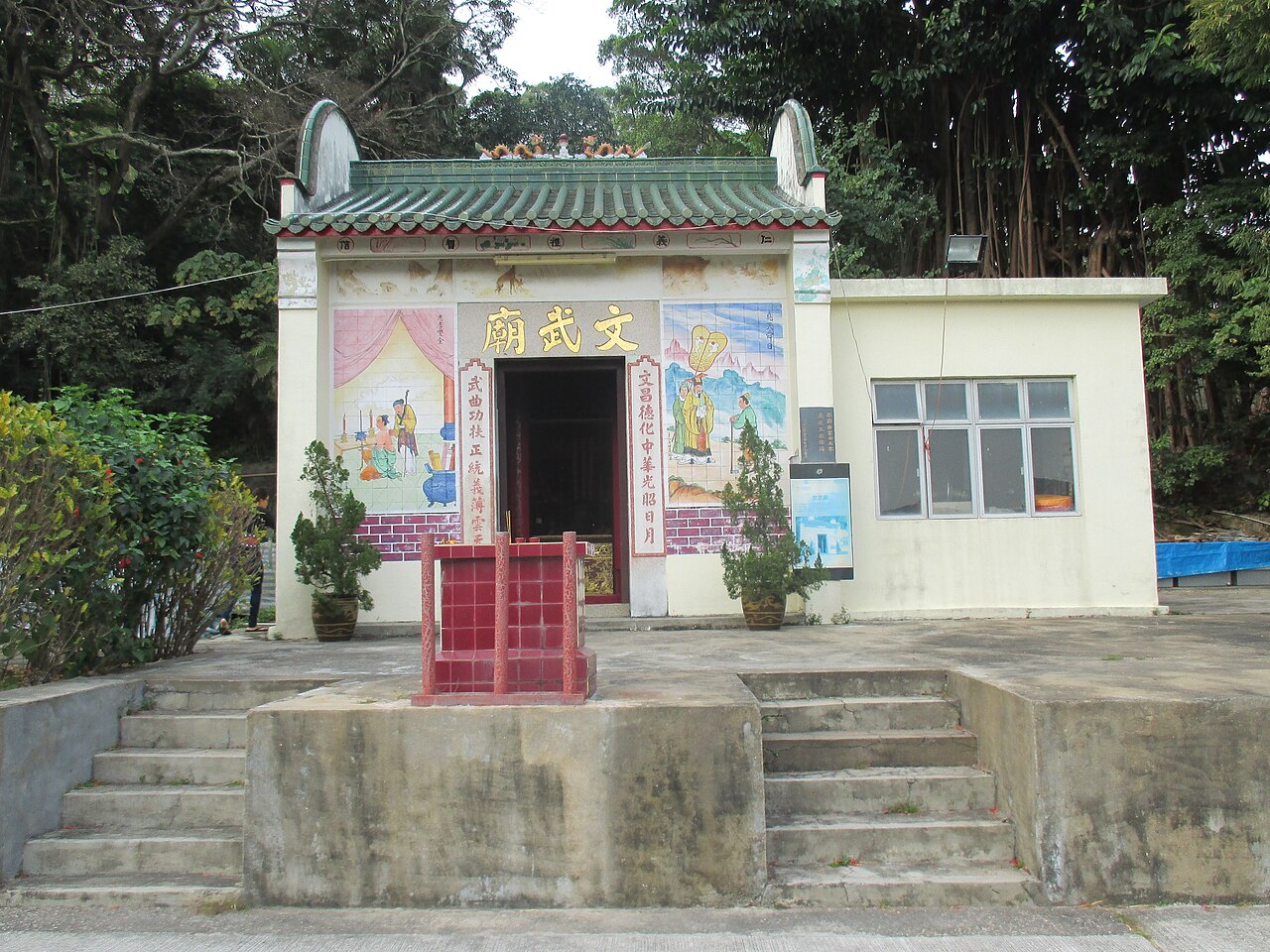 Man Mo Temple in Pak Ngan Heung, Mui Wo, Lantau Island, Hong Kong. The mural painting on the left of the facade represents "Yue Fei's Mother Tattooing Yue Fei".