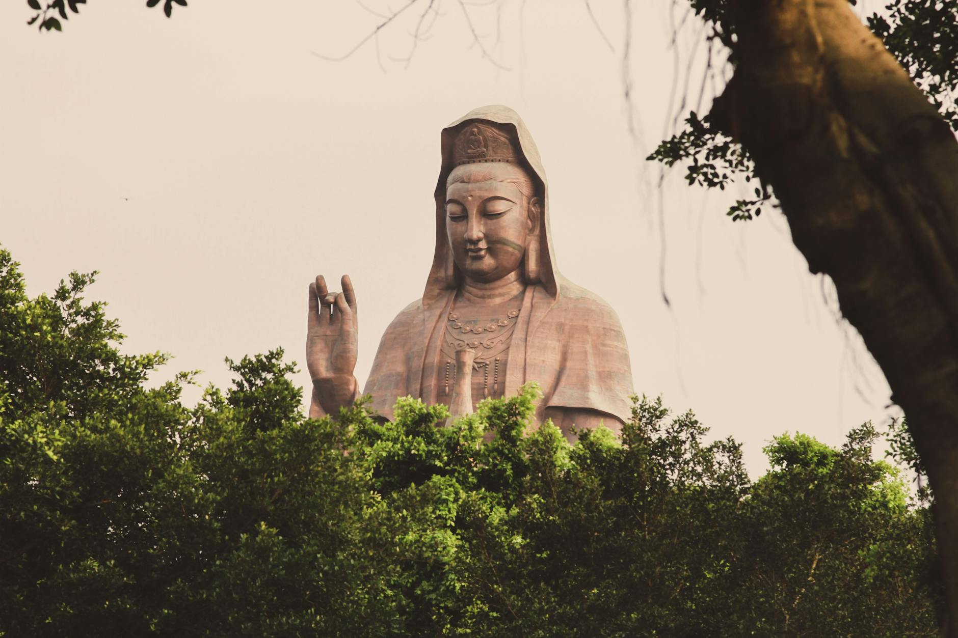 Majestic Guanyin statue amidst lush greenery at Mount Xiqiao, Guangdong, China.