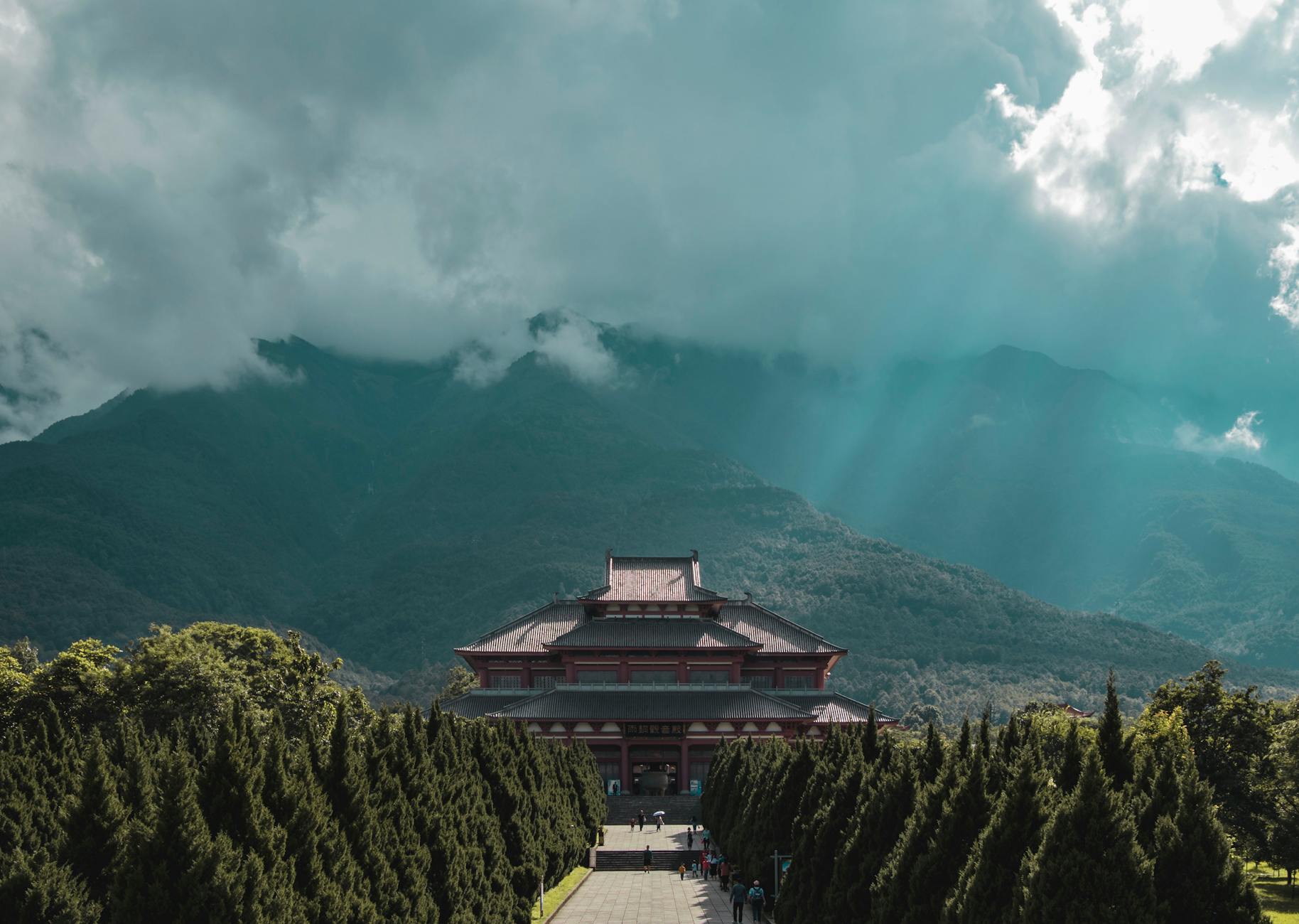 Majestic view of Chongsheng Temple surrounded by lush greenery and mountain backdrop in Yunnan, China.