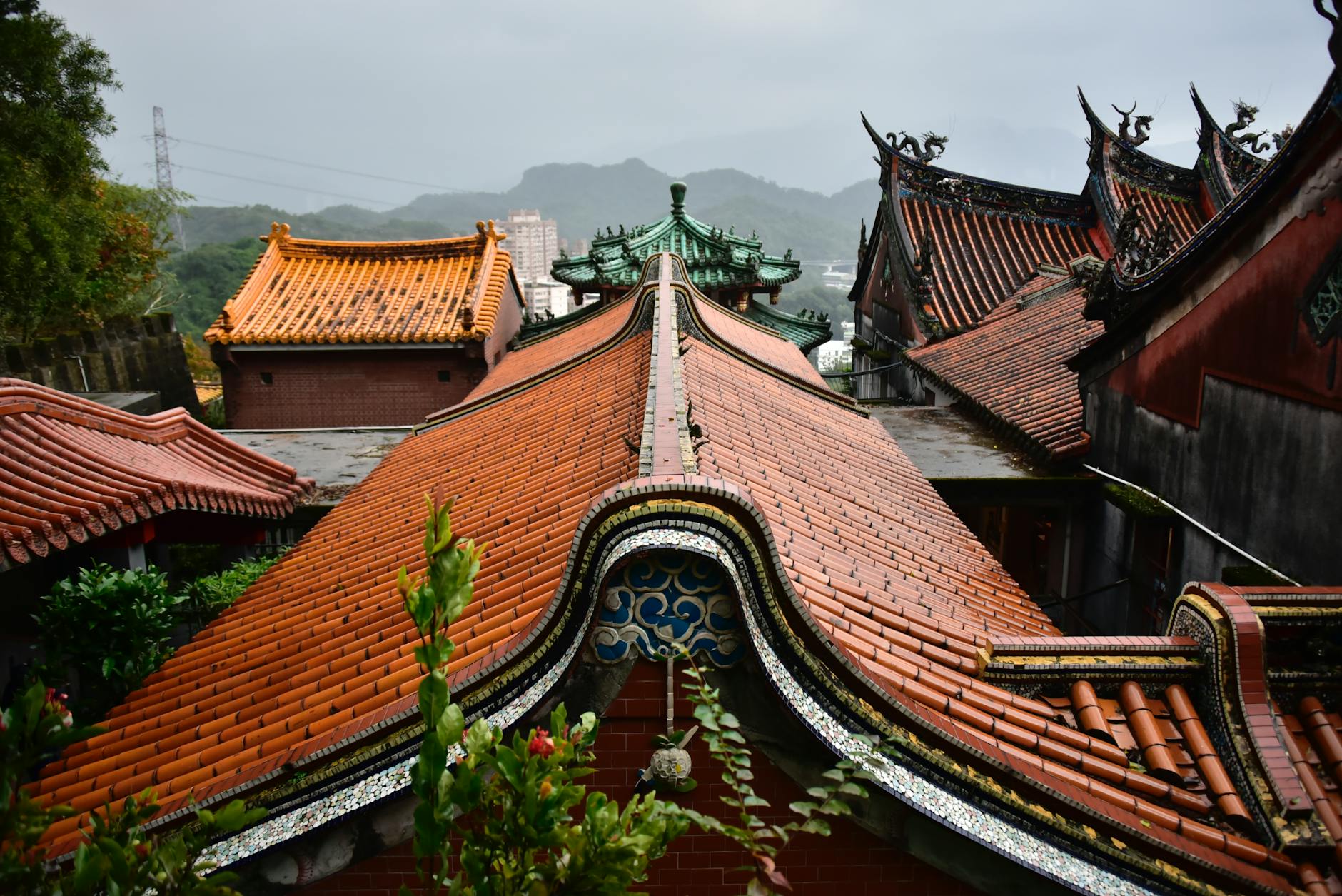 Beautiful view of traditional Asian temple roofs under a cloudy sky, highlighting architectural details.