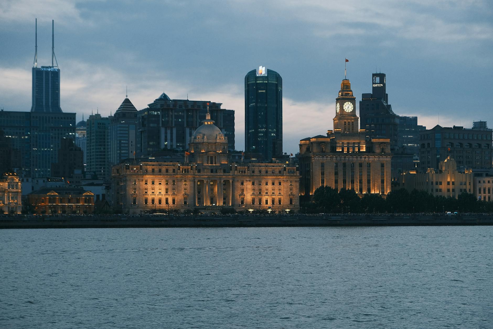 View of the iconic Shanghai skyline with illuminated buildings at twilight.