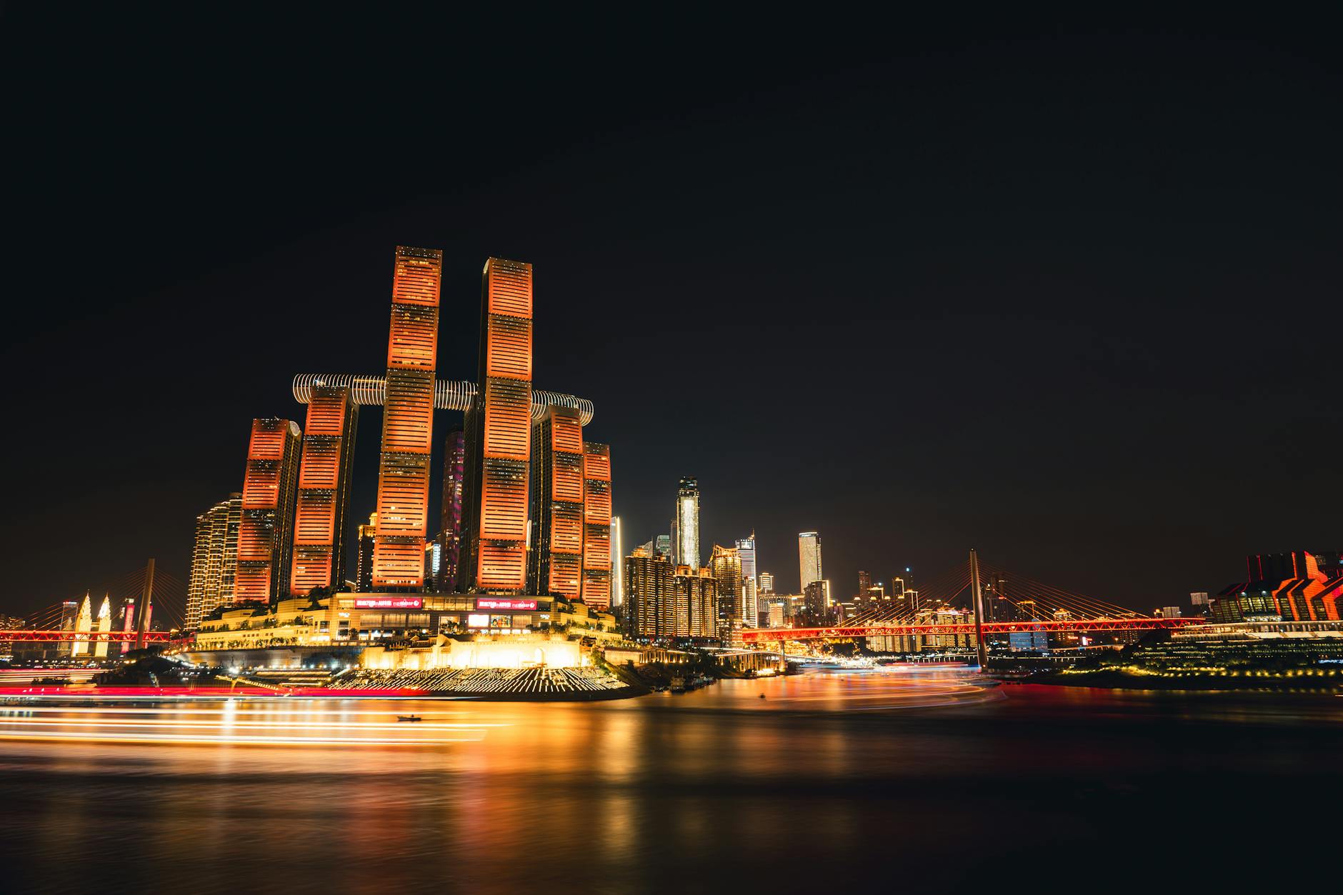 Stunning nightscape of Chongqing's illuminated skyline with iconic architecture reflecting on the river.