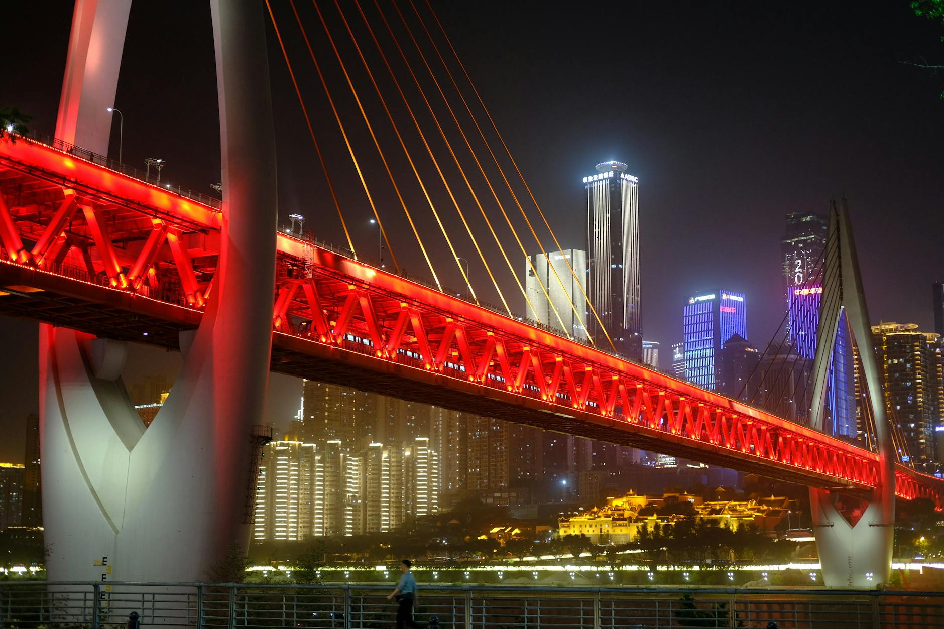 A stunning illuminated bridge in Chongqing at night with a vibrant cityscape in the background.