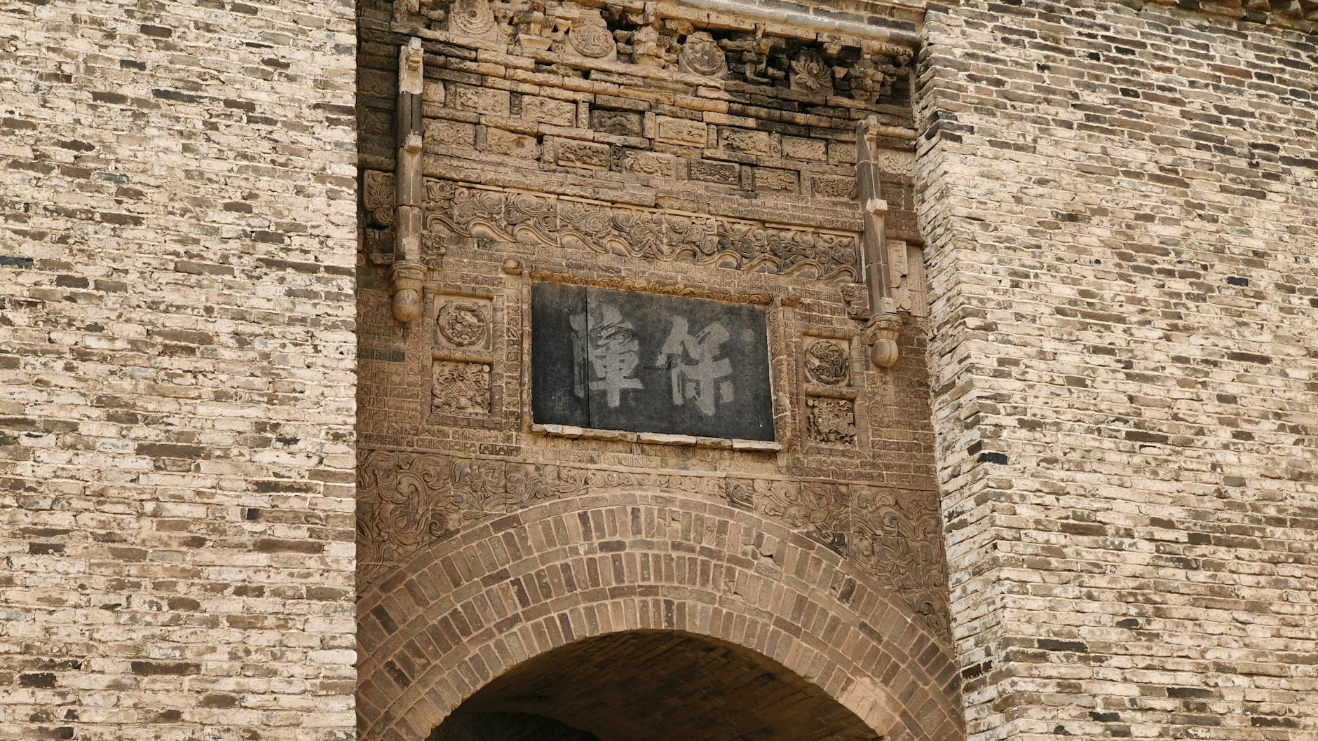 Close-up of a historic stone archway with intricate carvings in Datong, China.