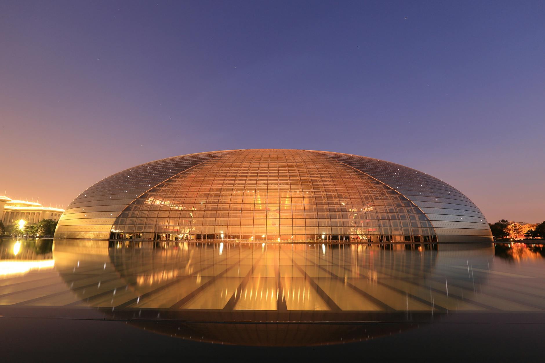 The iconic dome-shaped National Centre for the Performing Arts in Beijing, China, illuminated at twilight.