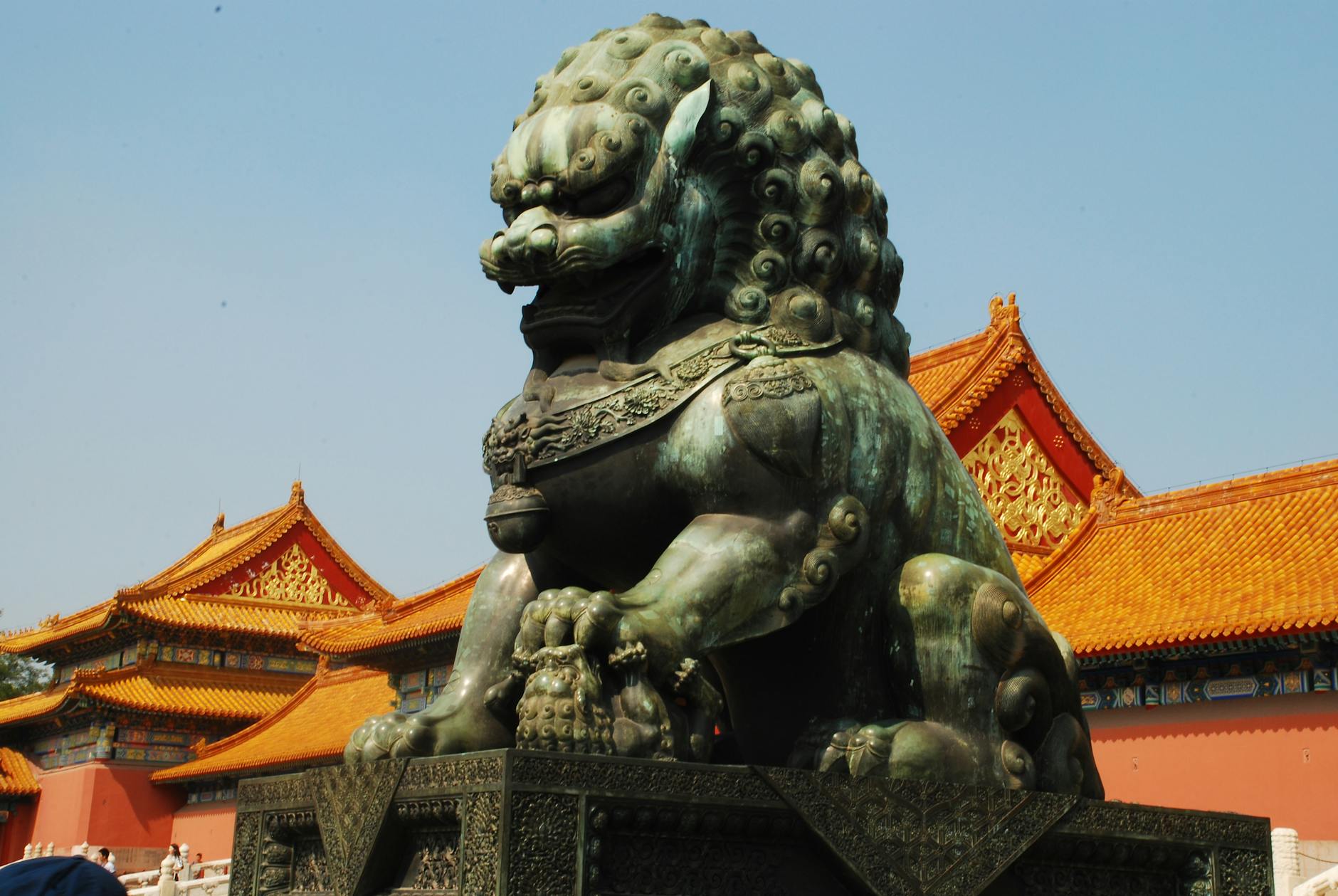 A stunning Fou Lion statue guards the Forbidden City in Beijing, China, under a clear sky.