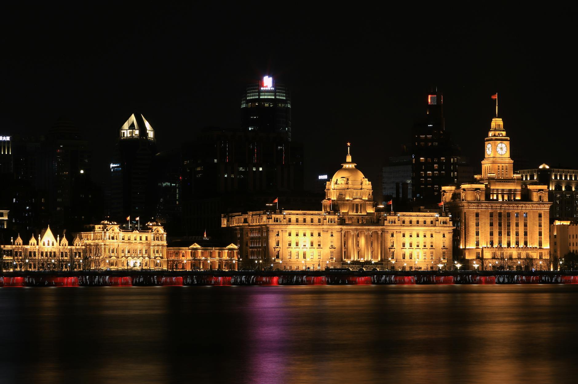 Dramatic night view of Shanghai Bund buildings beautifully illuminated along the Huangpu River.