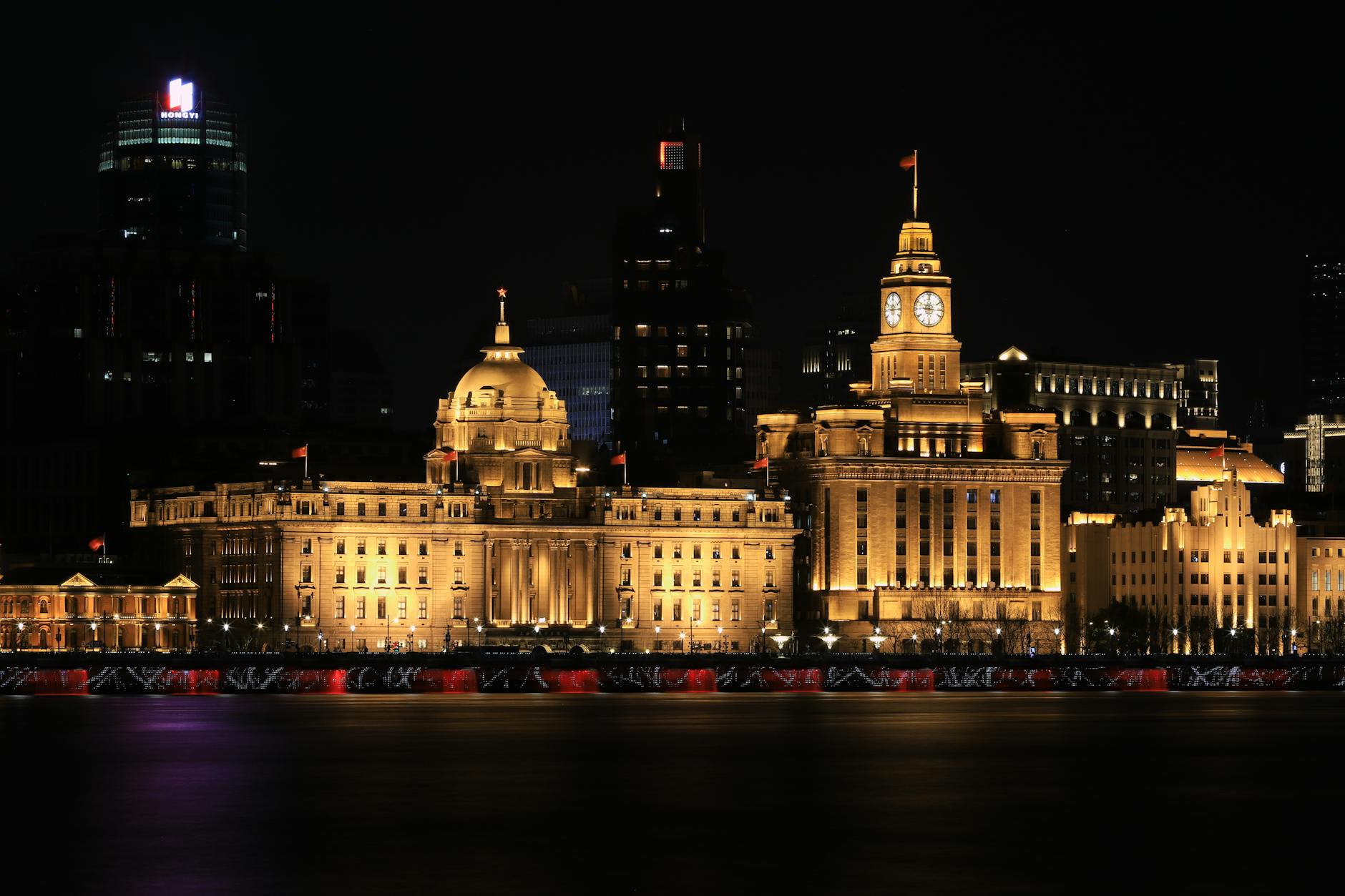 Night view of The Bund in Shanghai showcasing iconic historical buildings beautifully lit up.