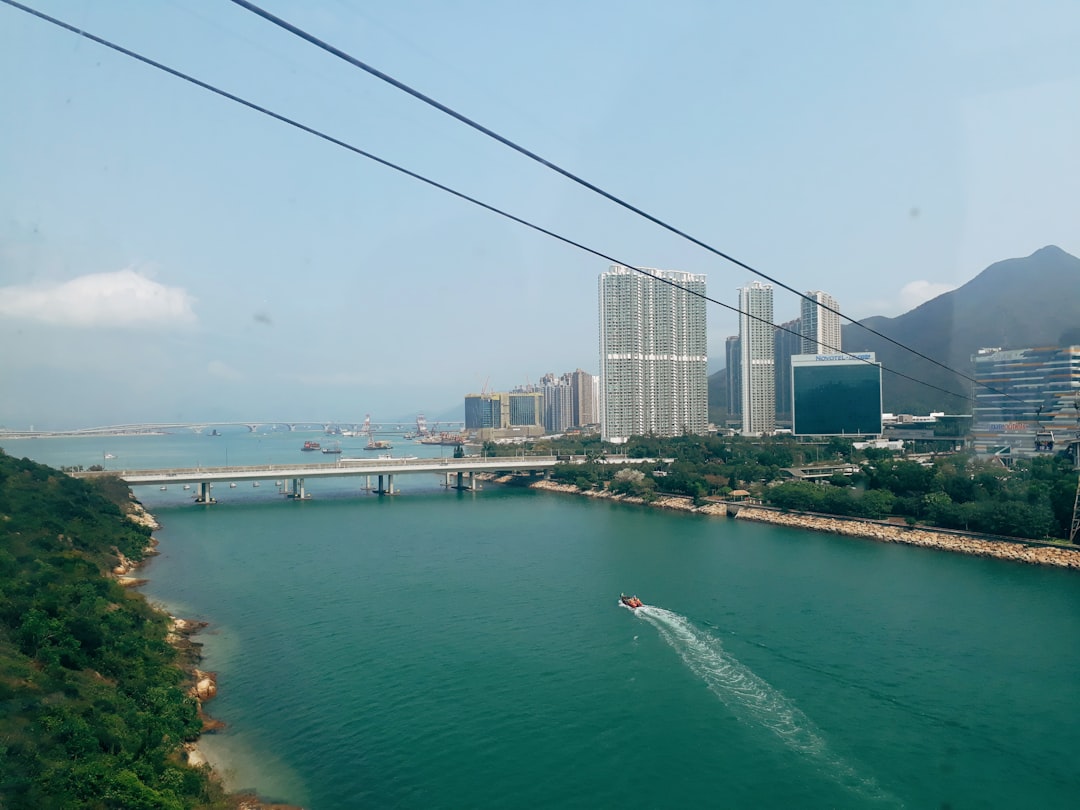 boat sailing near concrete bridge during daytime