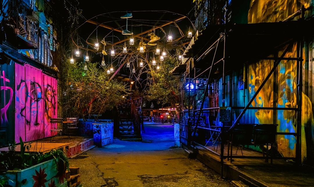 Graffiti-covered alleyway illuminated by string lights at night