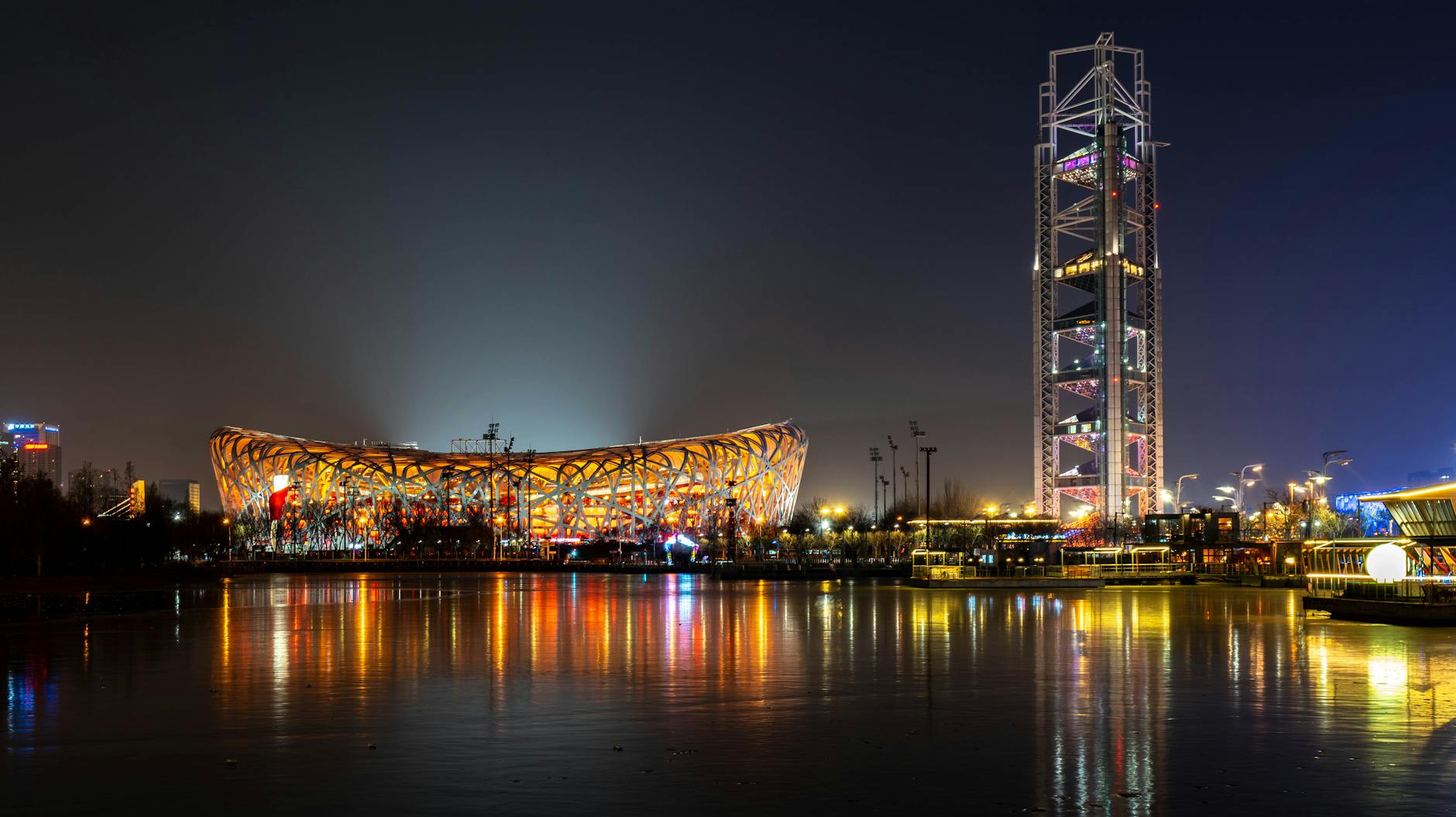 Stunning night shot of Beijing's Bird's Nest, reflecting vibrant city lights.