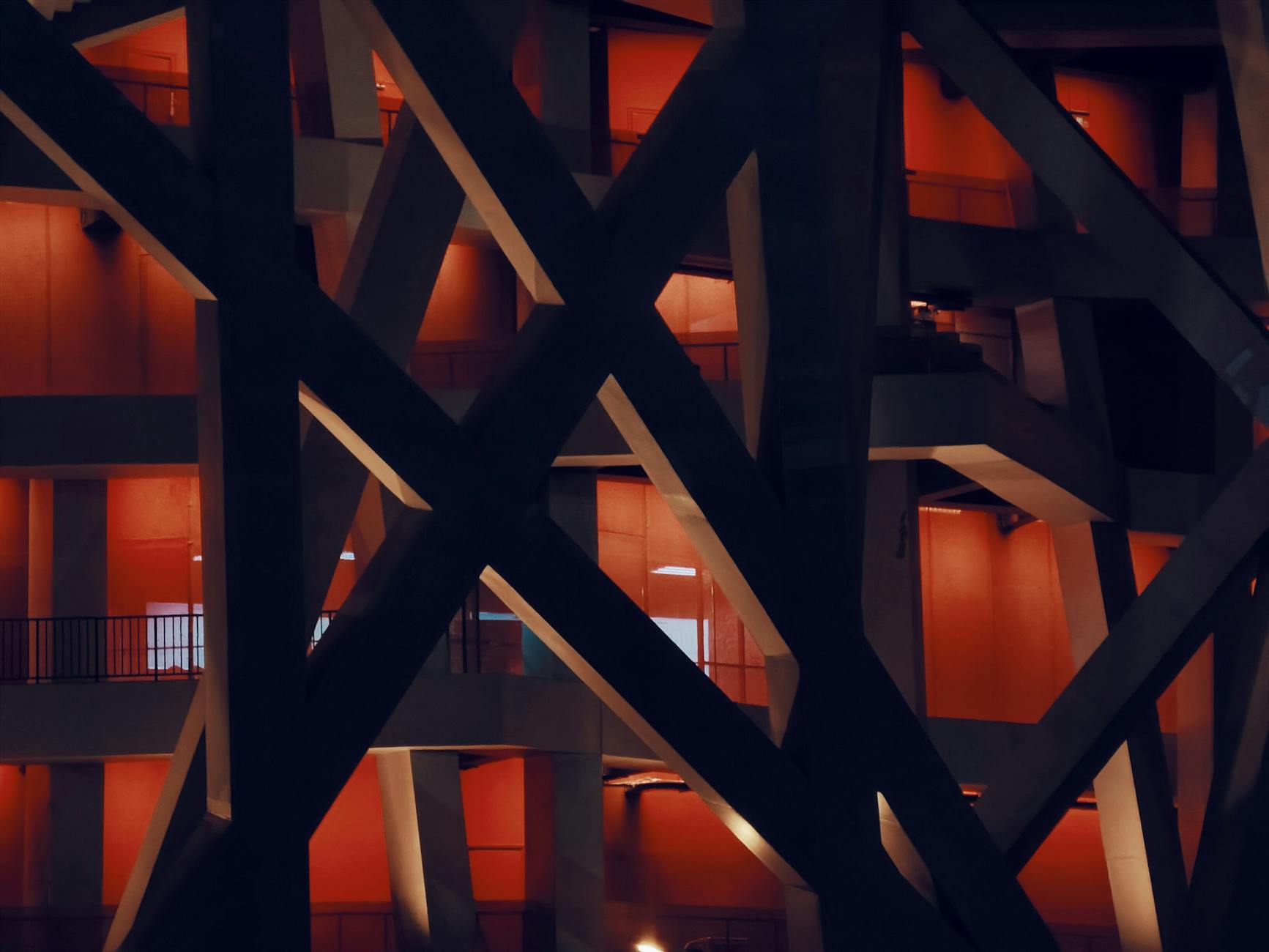 Close-up night view of the National Stadium in Beijing with unique architecture and red illumination.