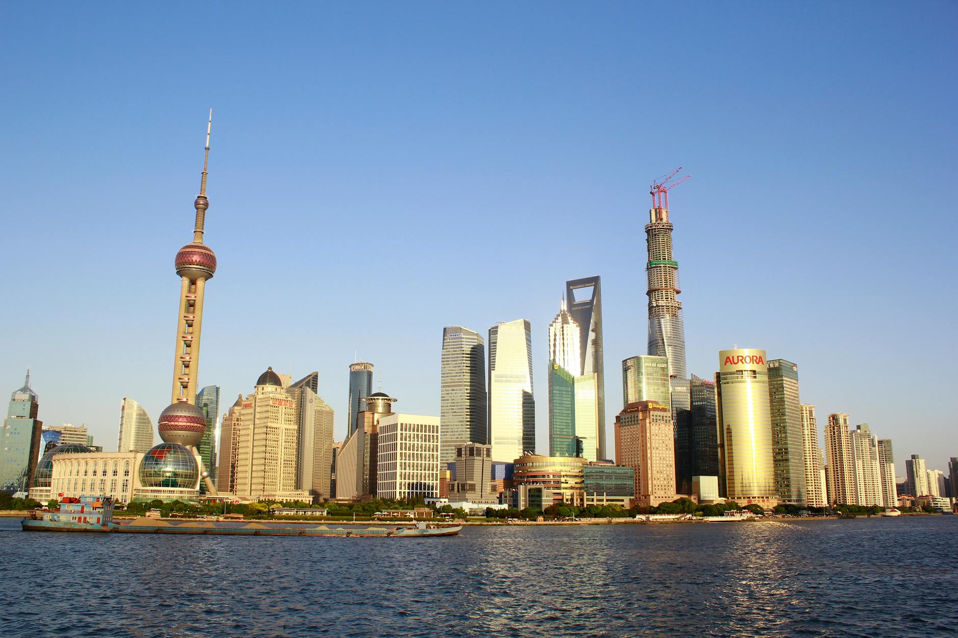 Stunning view of Shanghai's skyline featuring iconic skyscrapers along the waterfront under a clear blue sky.
