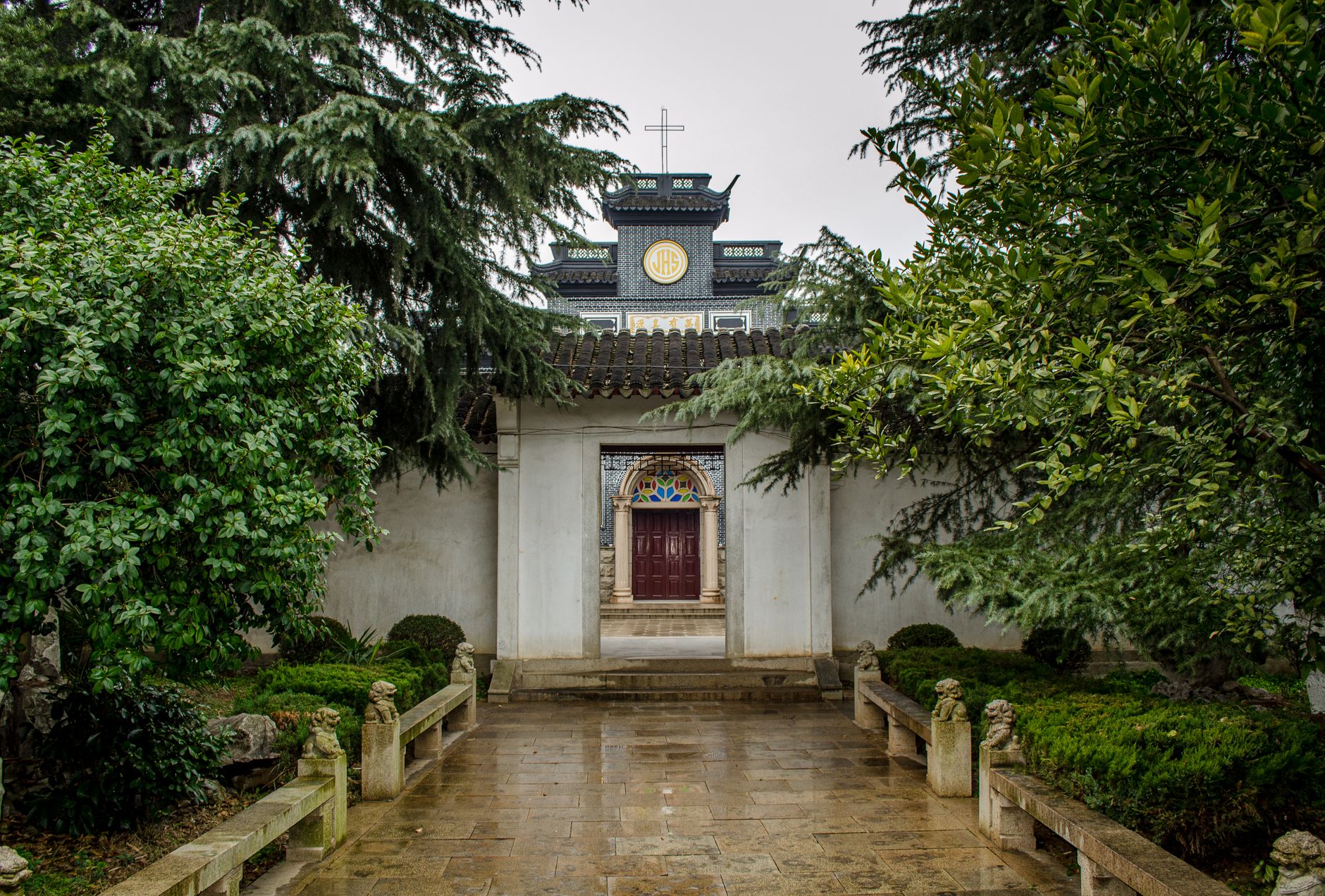 A picturesque traditional Chinese gate with lush greenery in Suzhou, China.
