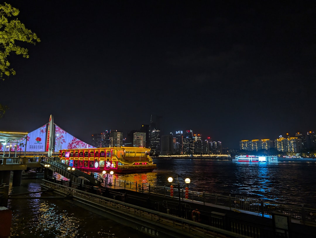 A brightly lit boat floats on the water at night.