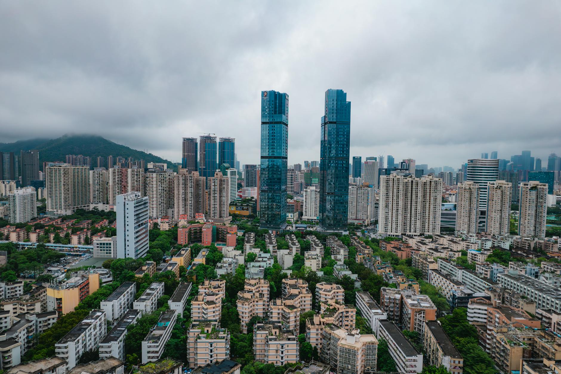Aerial view of Shenzhen's modern skyscrapers and urban landscape under cloudy skies.