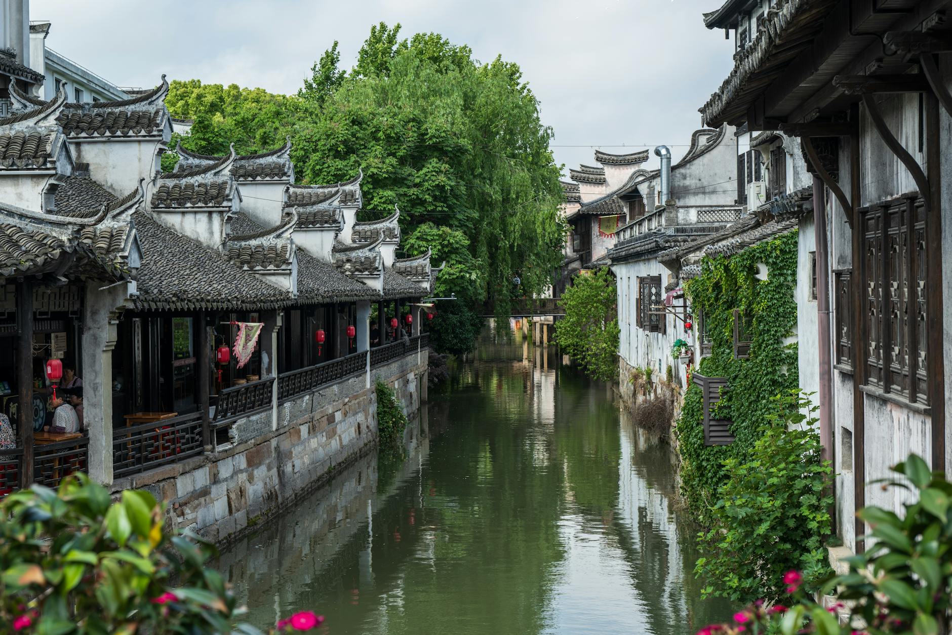 Scenic view of a historic Chinese water town with classic architecture lining a picturesque canal.