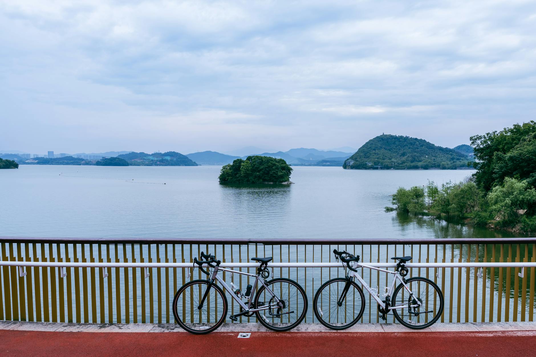 Two bicycles parked by a serene lake in Hangzhou, China, perfect for outdoor adventures.