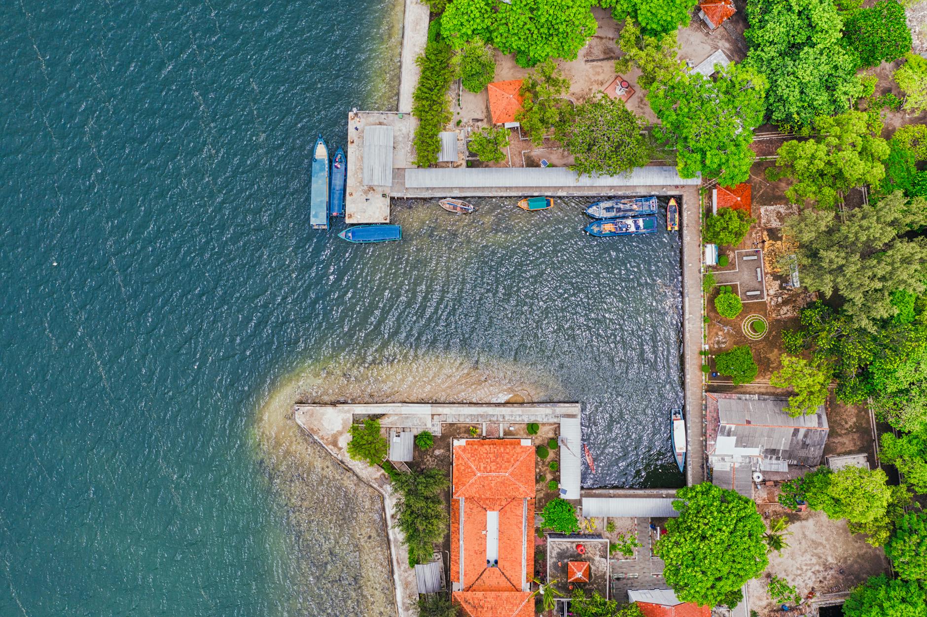 Aerial shot of docks and boats surrounded by greenery in Kepulauan Seribu, Indonesia.