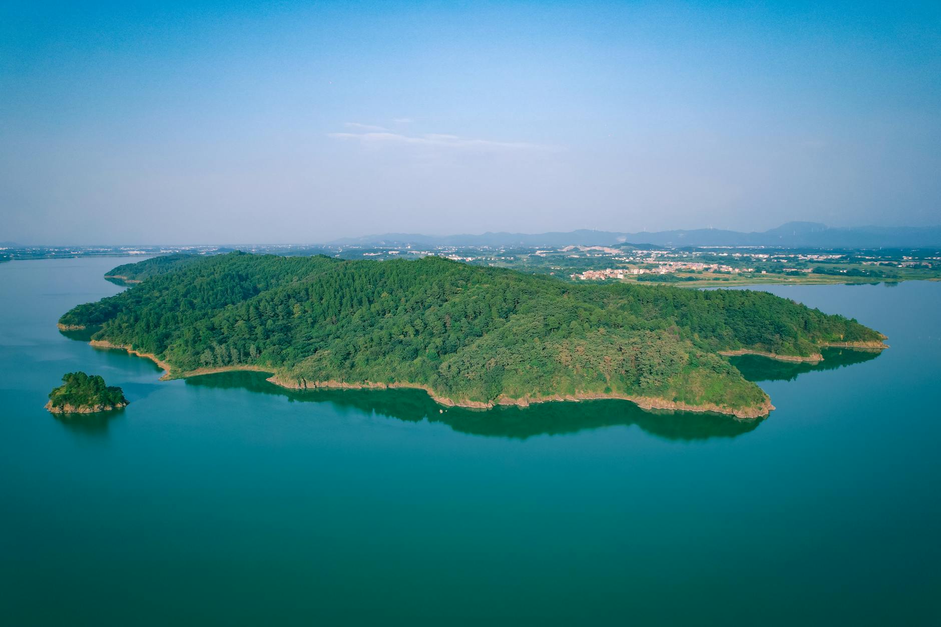 Scenic aerial view of lush green island surrounded by calm waters near Jiujiang, China.