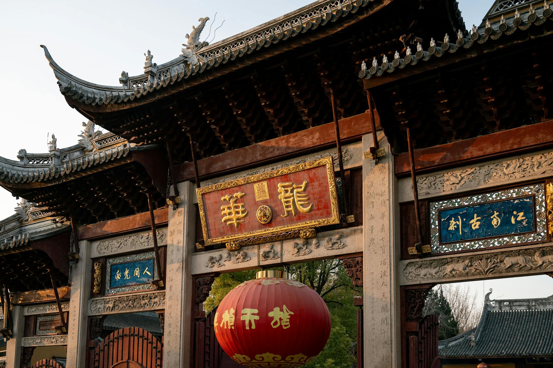 A striking traditional Chinese gate in Shanghai, illuminated by the setting sun, showcasing intricate architectural details.