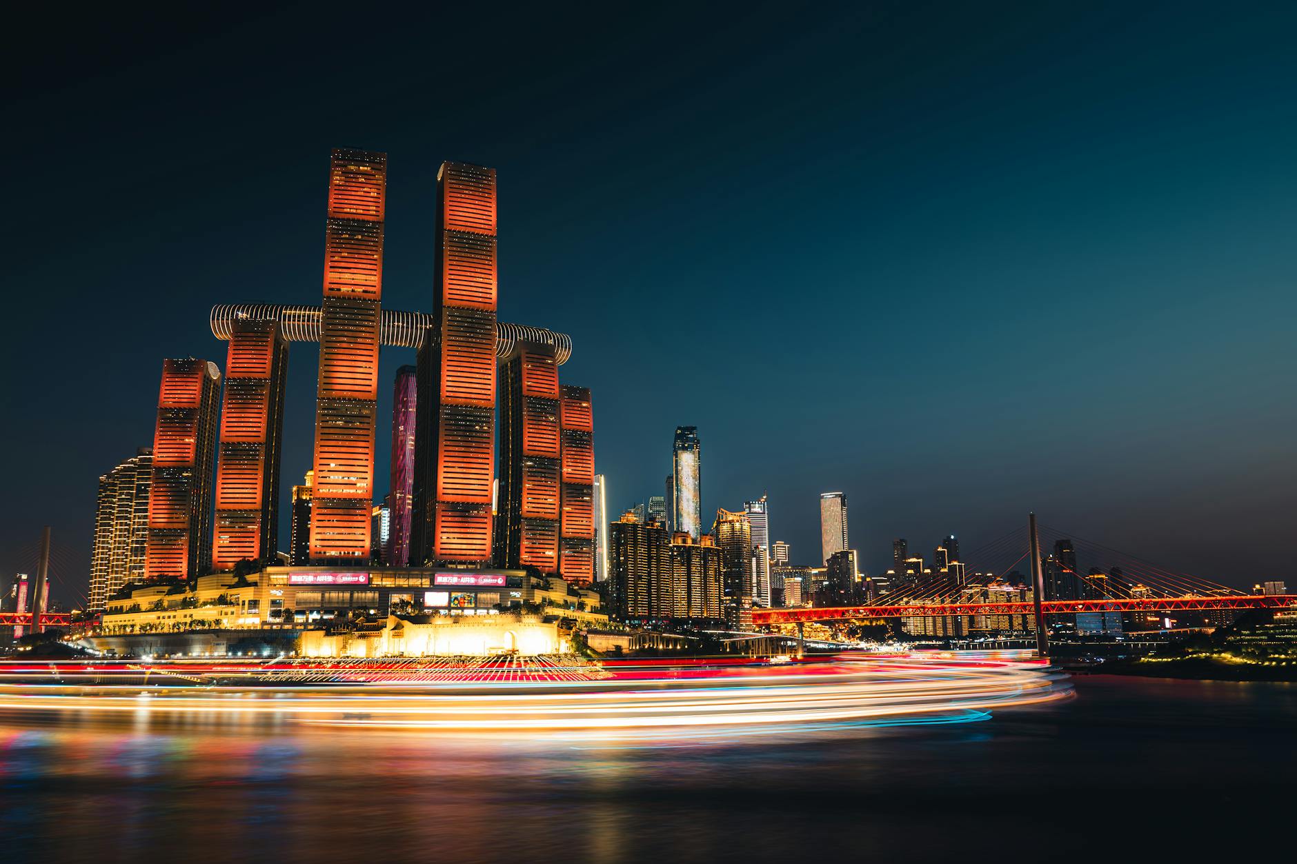 Vibrant night view of Chongqing skyline featuring the iconic Raffles City illuminated.